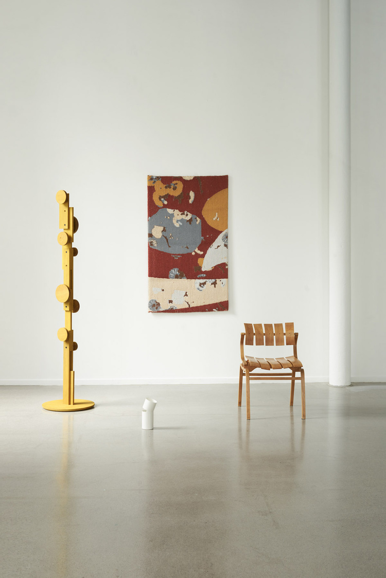 Unika Auction by Bjørn van den Berg and Falke Svatun — A spare exhibition view presents three distinct design objects against white walls and polished concrete flooring.