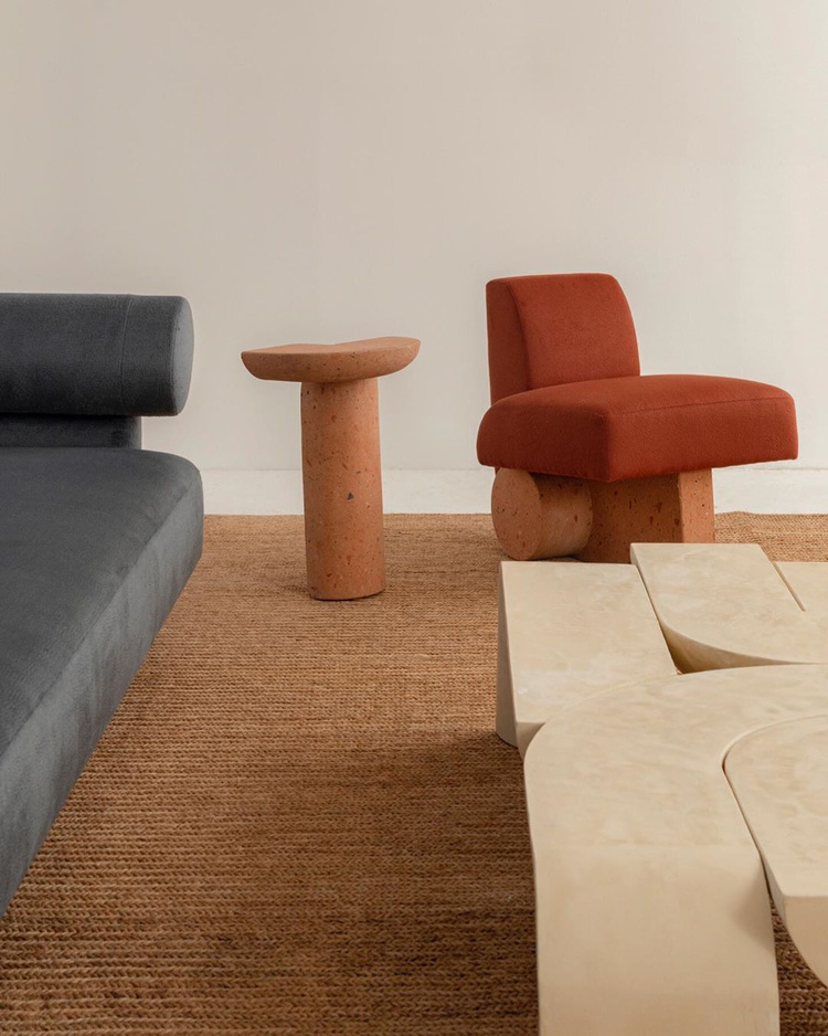Kosa Collection by Ian Felton — The Kosa Collection presents three distinct seating and table objects arranged on a woven natural fiber rug.