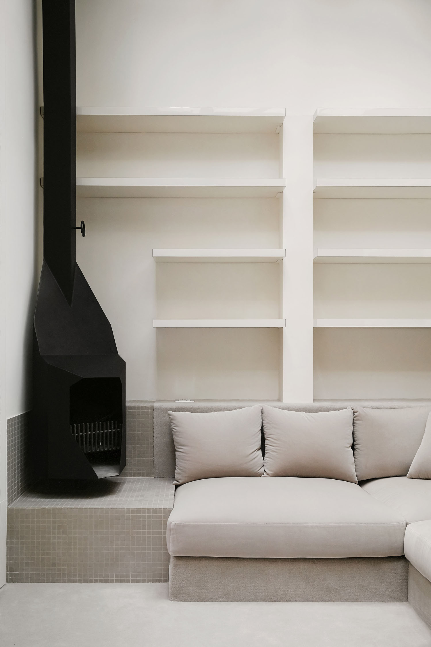 Barcelona Apartment Renovation by Arquitectura-G — A sunken lounge occupies the lower level of this Barcelona apartment, its cream linen upholstery anchoring the stepped interior.