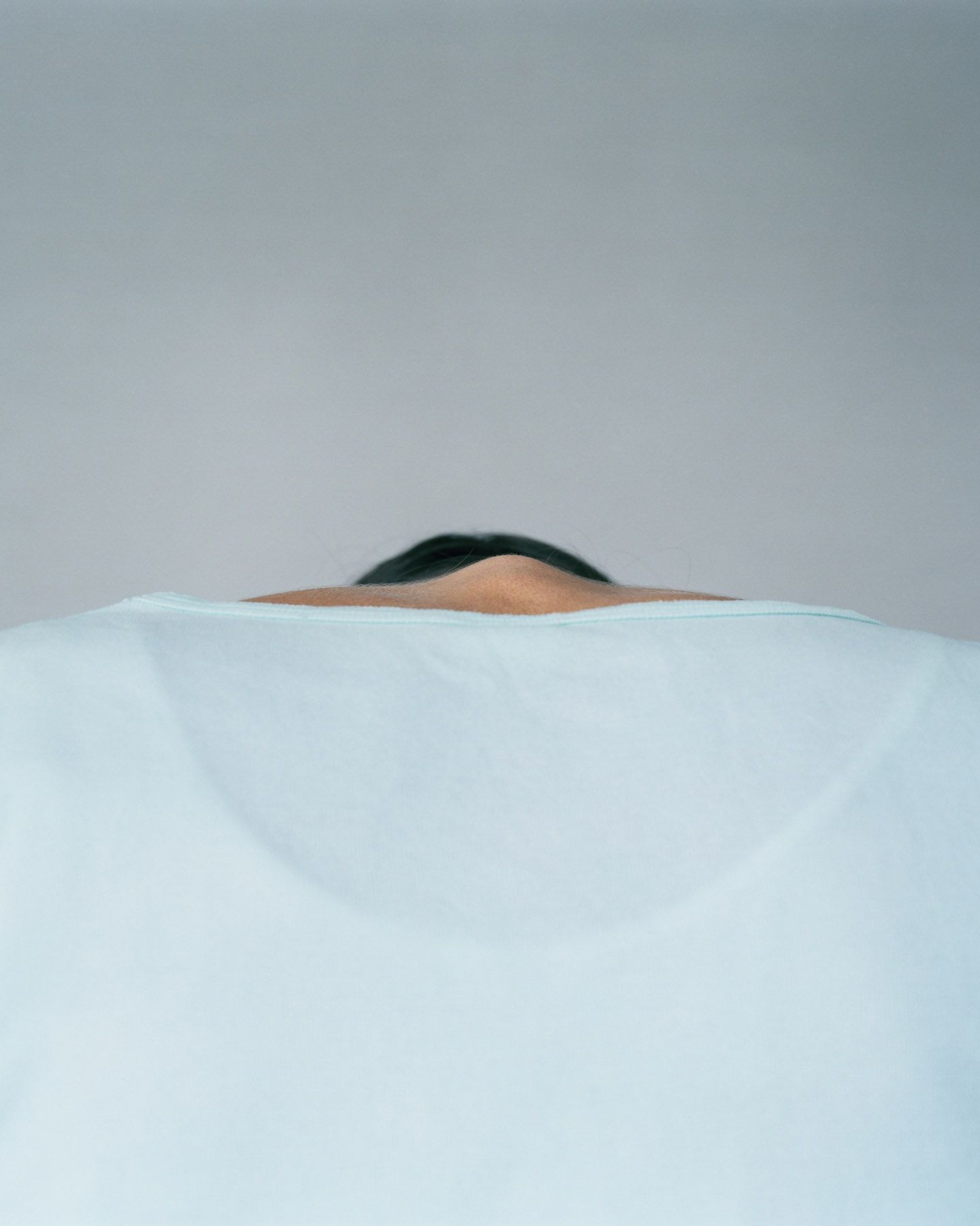 The Circle and the Line by Erik Östensson — A human figure lies beneath white linen, creating a peaked topographical form.