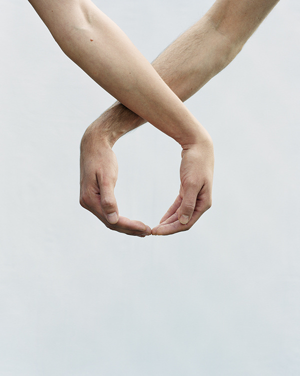 The Circle and the Line by Erik Östensson — Two pale arms cross to form a circular void against a neutral ground, their skin rendered in warm ochre tones.