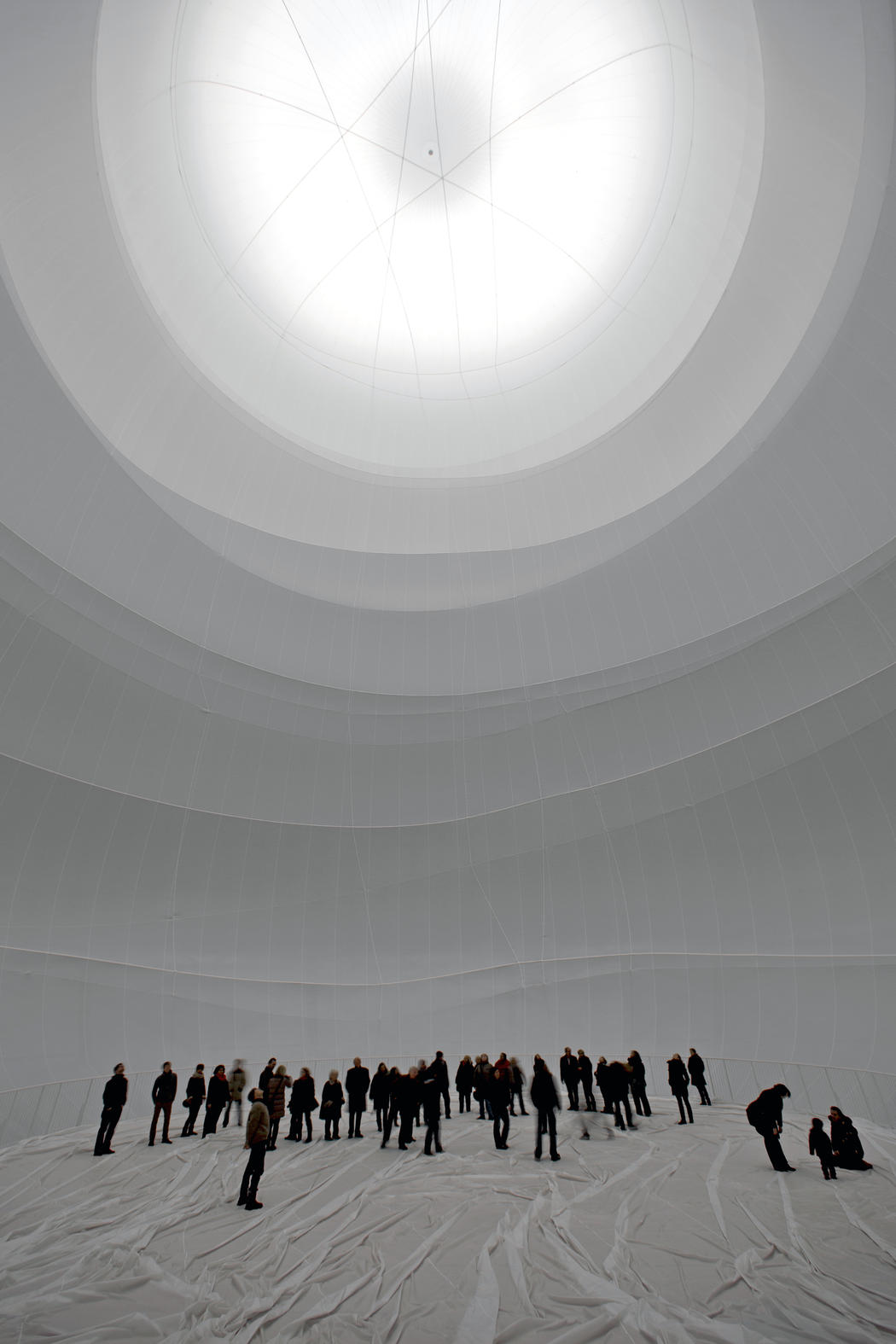 Big Air Package by Christo — Interior view of Big Air Package capturing the inflated fabric envelope at zenith, where radial cable supports converge at a central point 90 meters above...