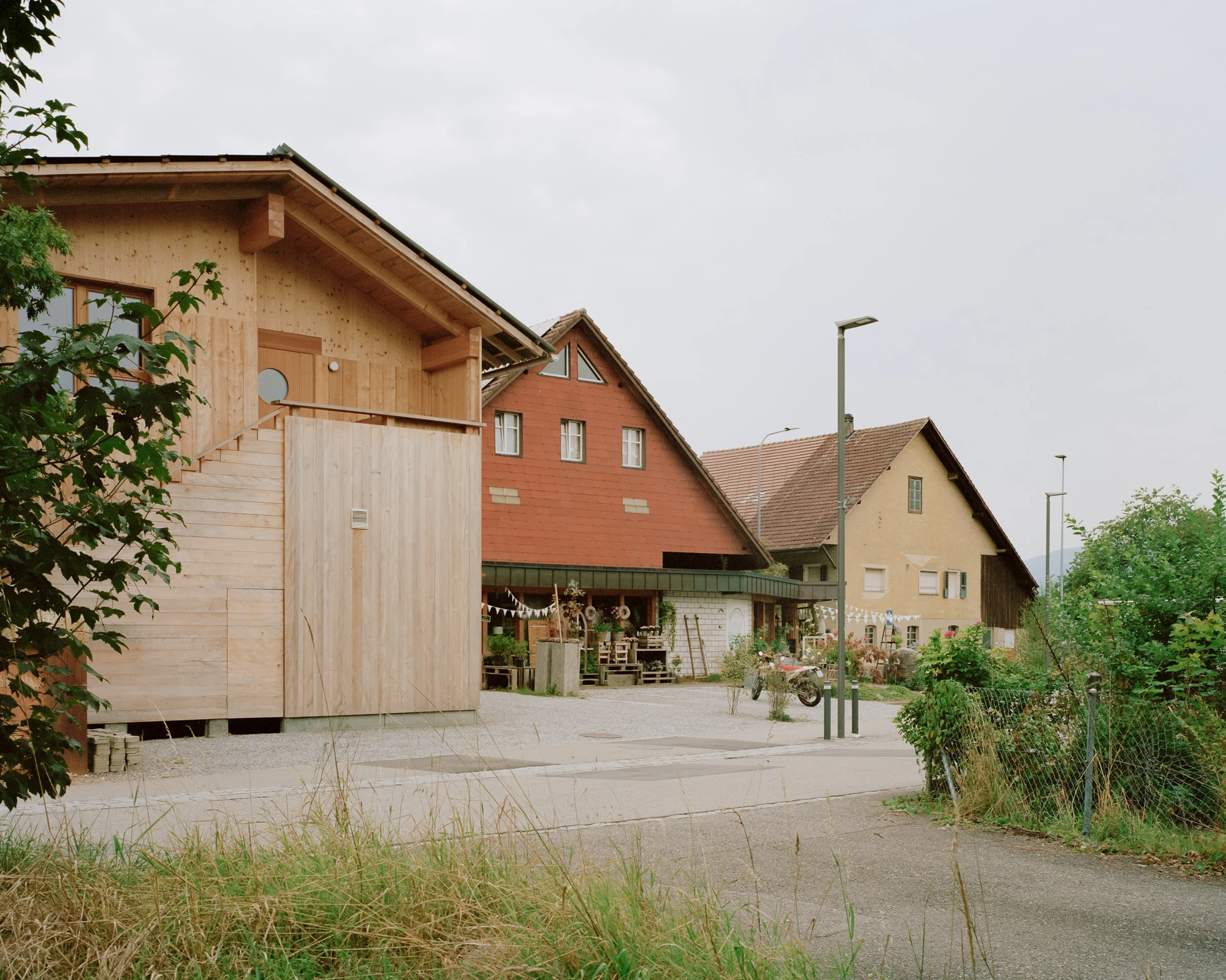 House in Deitingen by studio ou — The residential building by studio ou presents a pitched-roof gabled form clad in light timber boarding, positioned within Deitingen's village core...