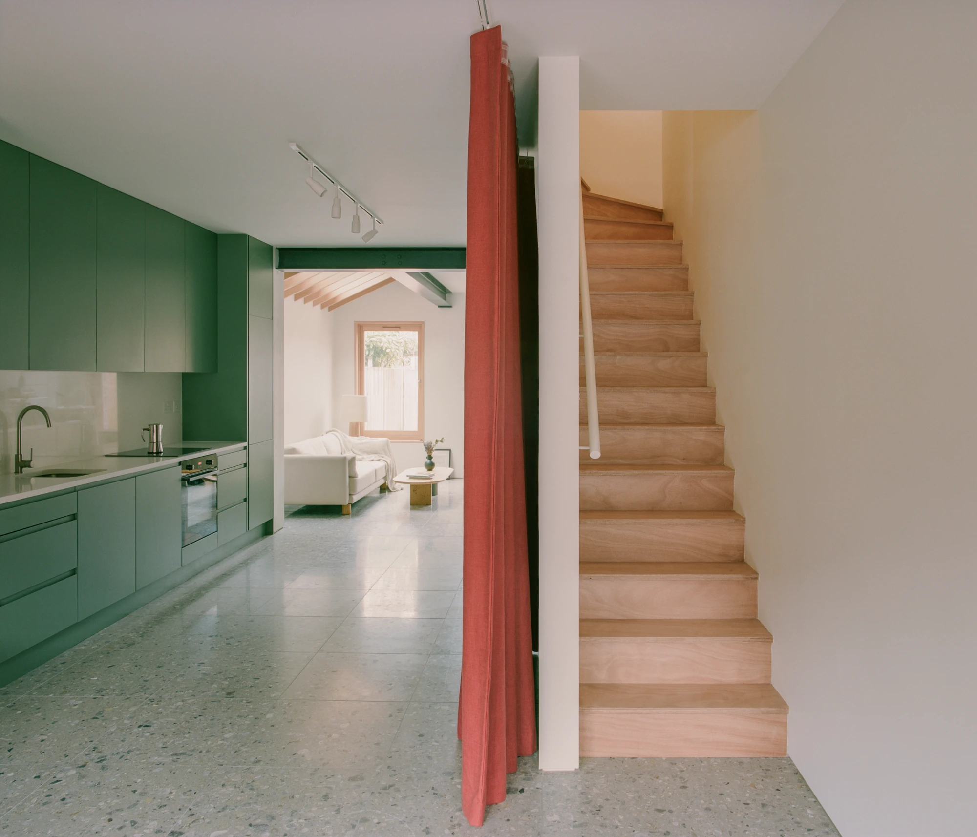 Walthamstow House by PSL — A staircase intervention divides the ground floor of the Victorian terraced house, its timber treads ascending toward natural light.