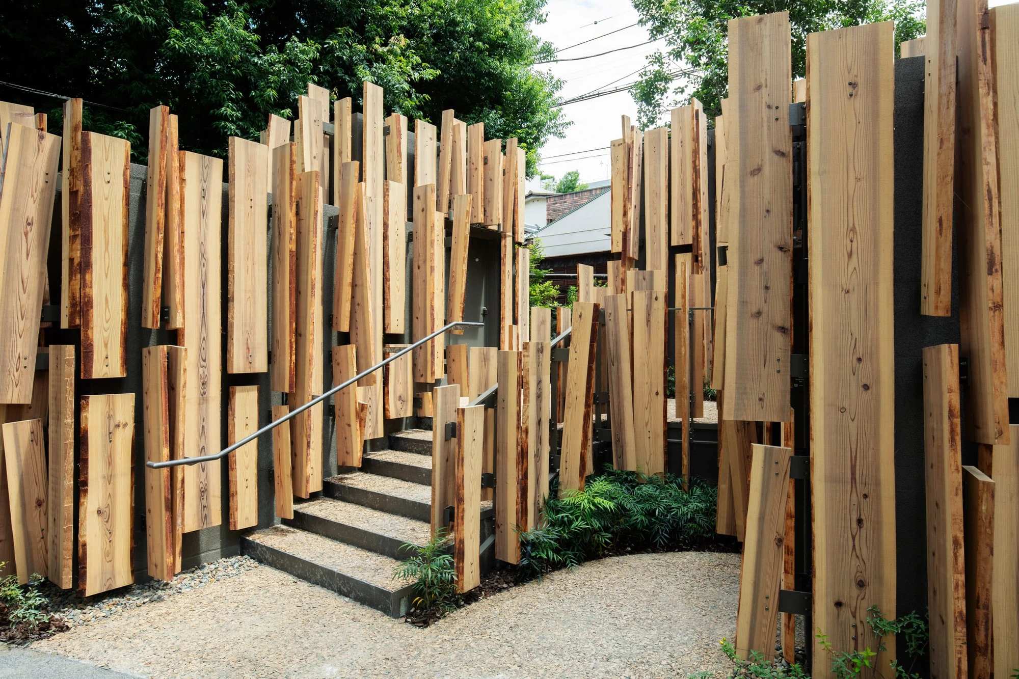 A Walk in the Woods by Kengo Kuma — A Walk in the Woods by Kengo Kuma employs vertical cedar slats of staggered heights to create a permeable timber screen that defines a passage through the...