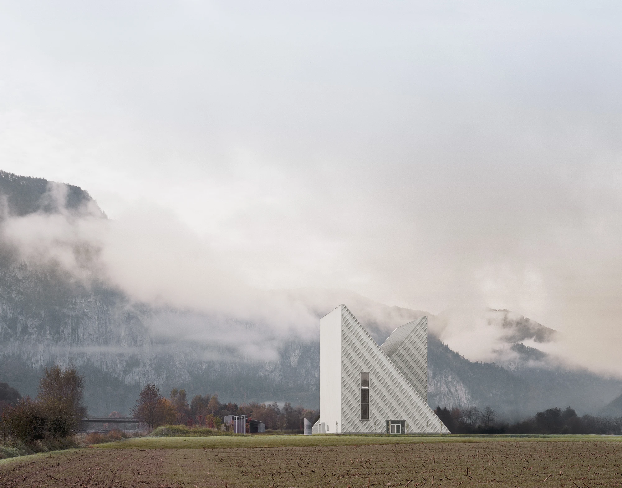 Dynafit Headquarters by Barozzi Veiga — Twin pyramidal volumes clad in white render with diagonal quilted surface pattern meet at a sharp apex, their inclined planes creating acute angular...