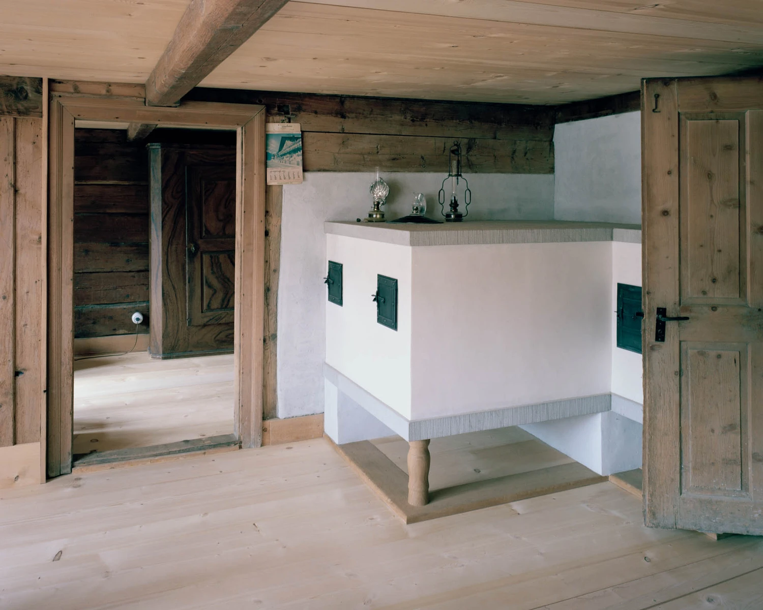 The Gässli5 by allen + crippa architektur — Interior view of the relocated timber-frame structure showing post-and-beam construction with exposed wooden ceiling beams and load-bearing posts.