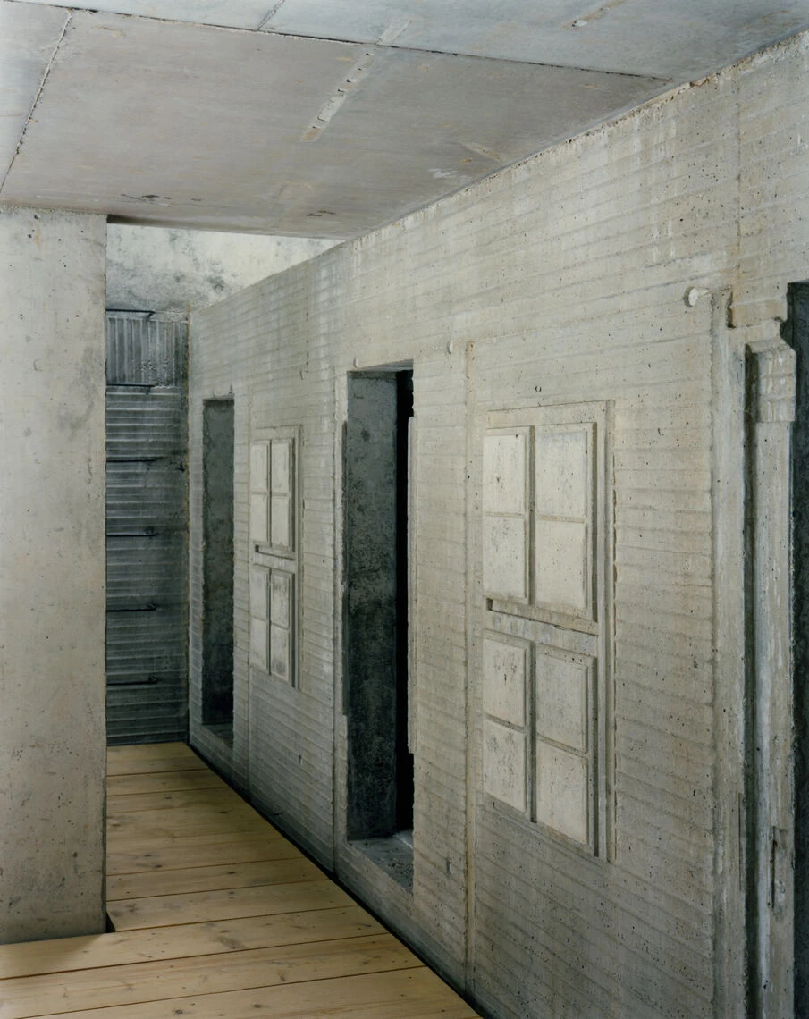 Hut on Fichtelberg by AFF Architekten — Interior corridor of cast concrete construction showing board-formed finish with weathered surface patina.