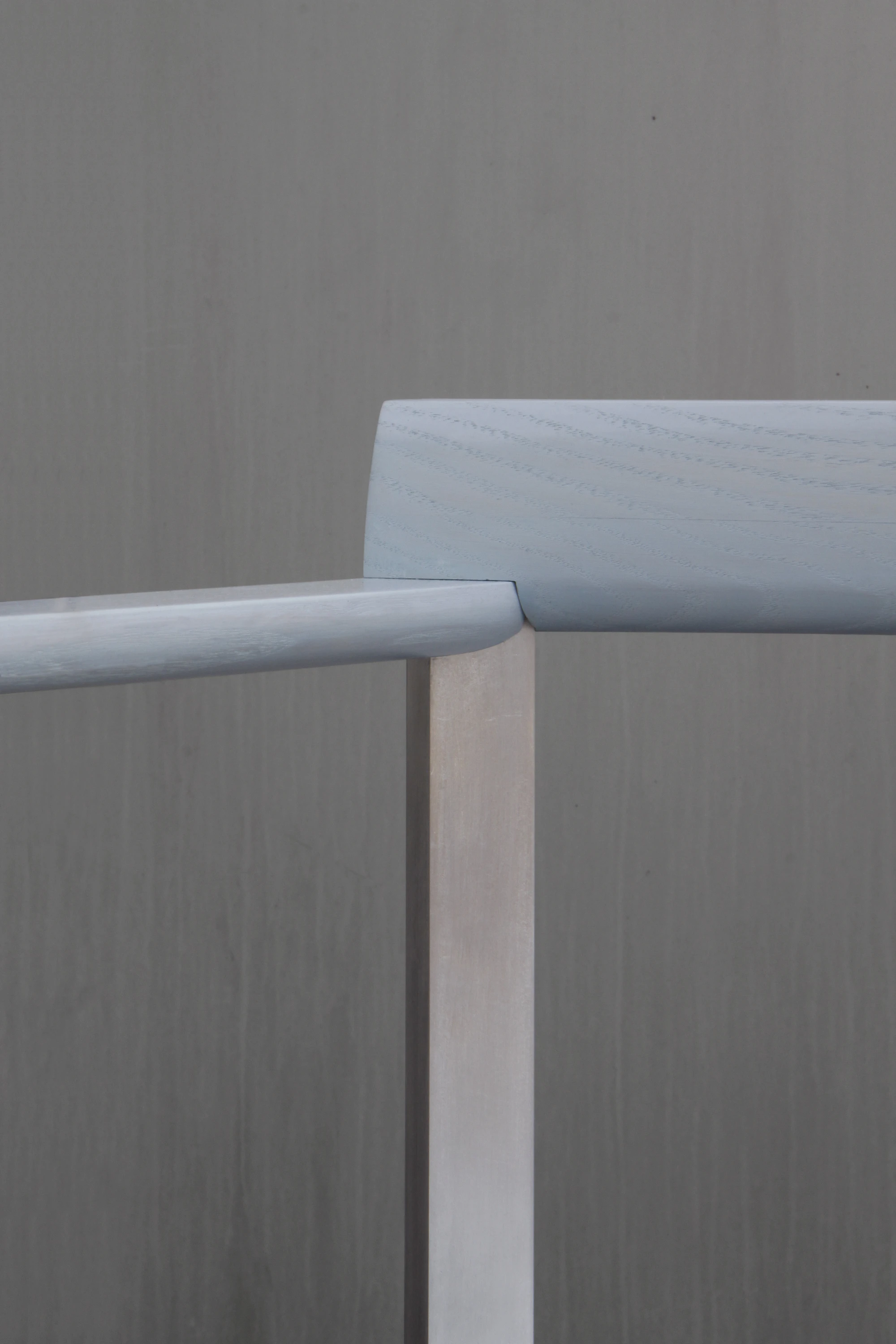 SQZY Chair by Timo Wuchner — Detail view of the SQZY Chair's joinery, isolating the intersection where the cylindrical backrest rail meets the vertical support post.