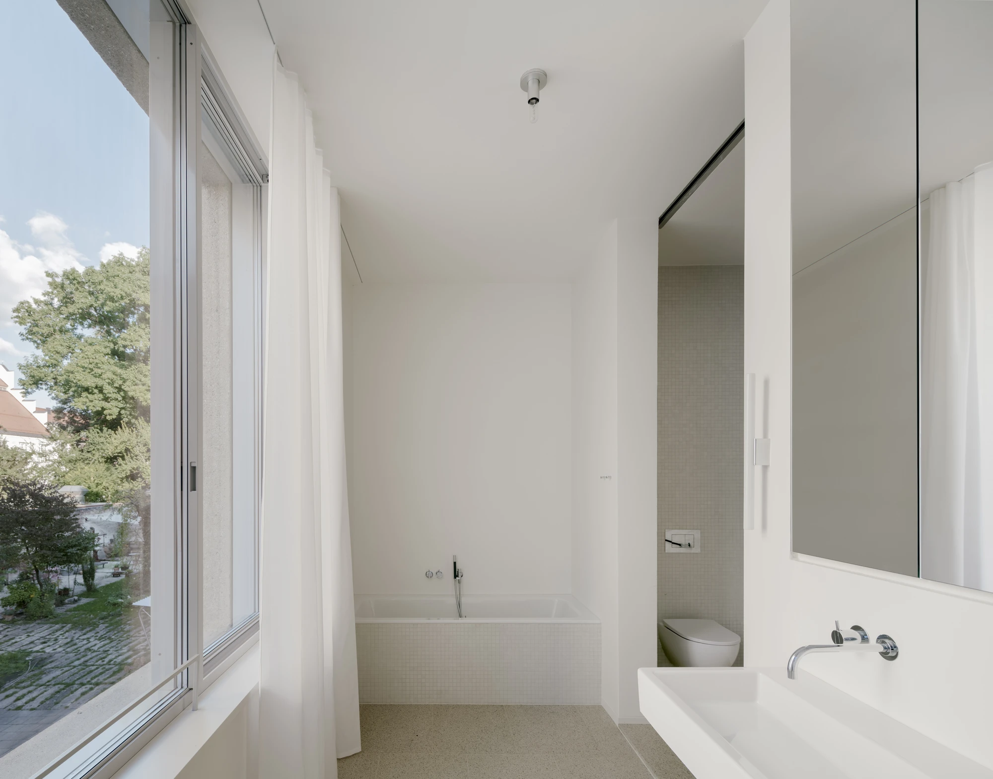 Ursulastraße 6 by Studio Mark Randel — A minimalist bathroom in Munich's Ursulastraße 6 reveals the project's restrained material vocabulary.