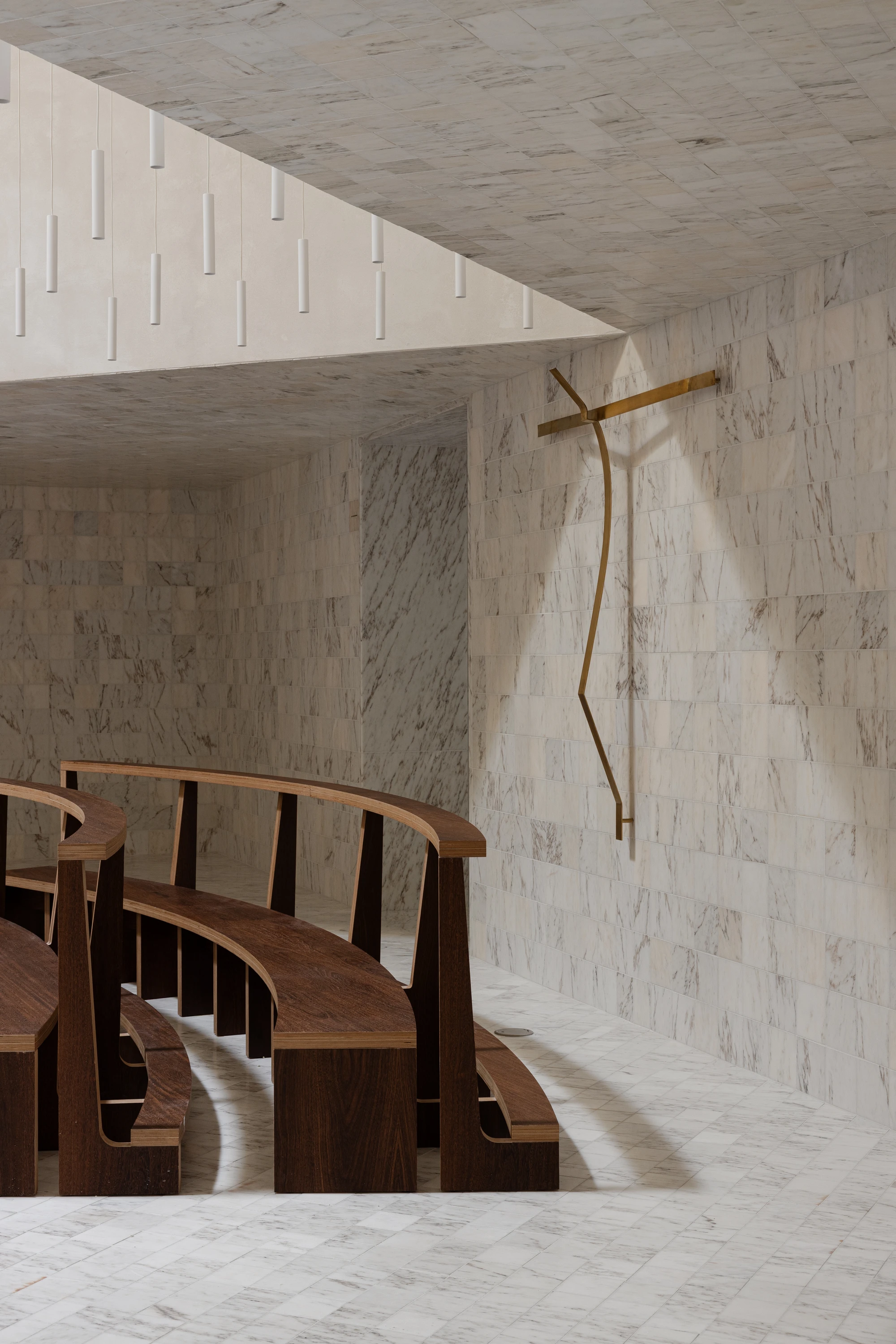 Da Boavista Church by Matos Gameiro arquitectos + atelier bugio — Interior view of the Da Boavista Church reveals a monolithic marble-clad wall defining the liturgical space.
