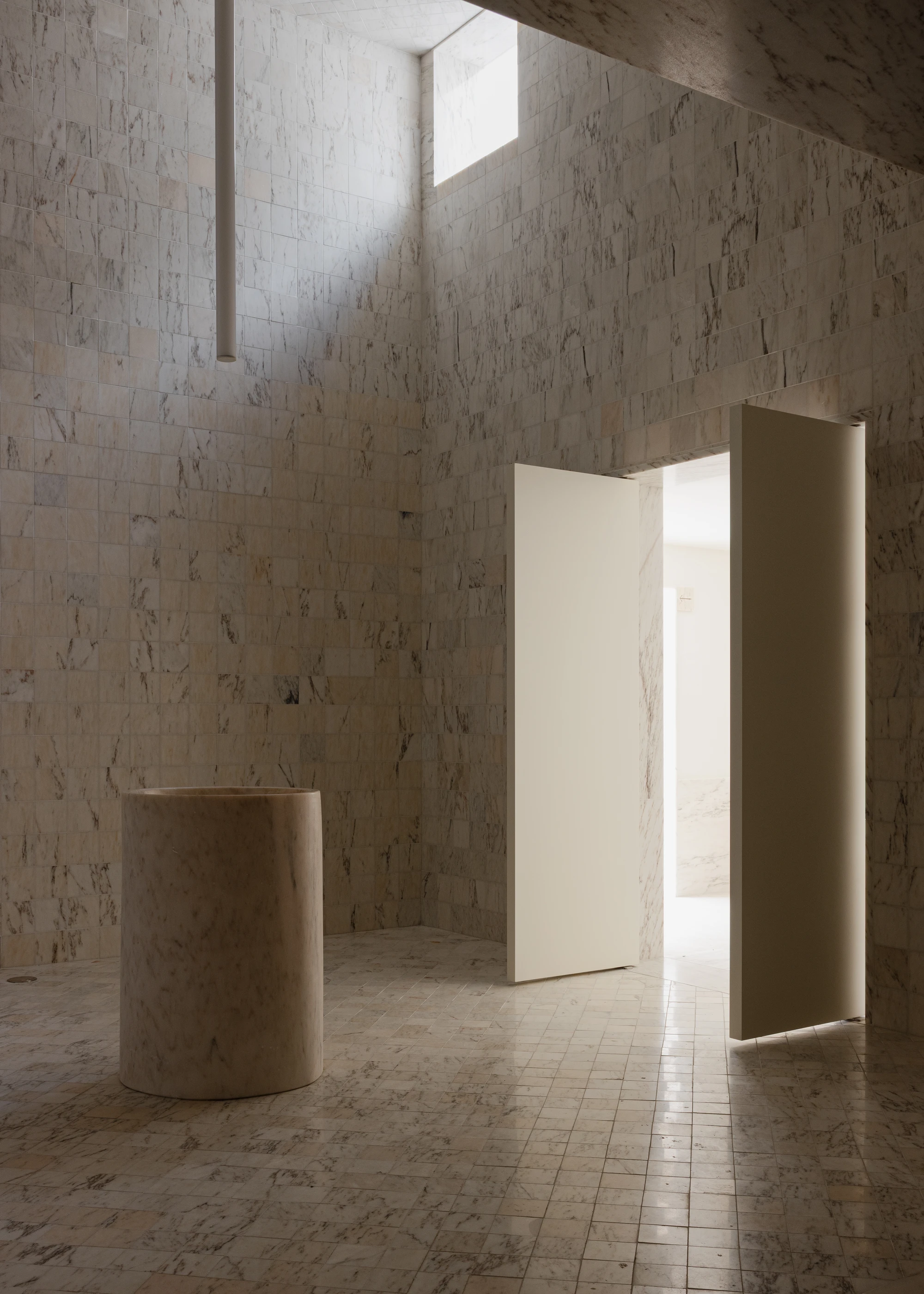 Da Boavista Church by Matos Gameiro arquitectos + atelier bugio — Interior passage of rendered marble-clad walls with geometric tile flooring.