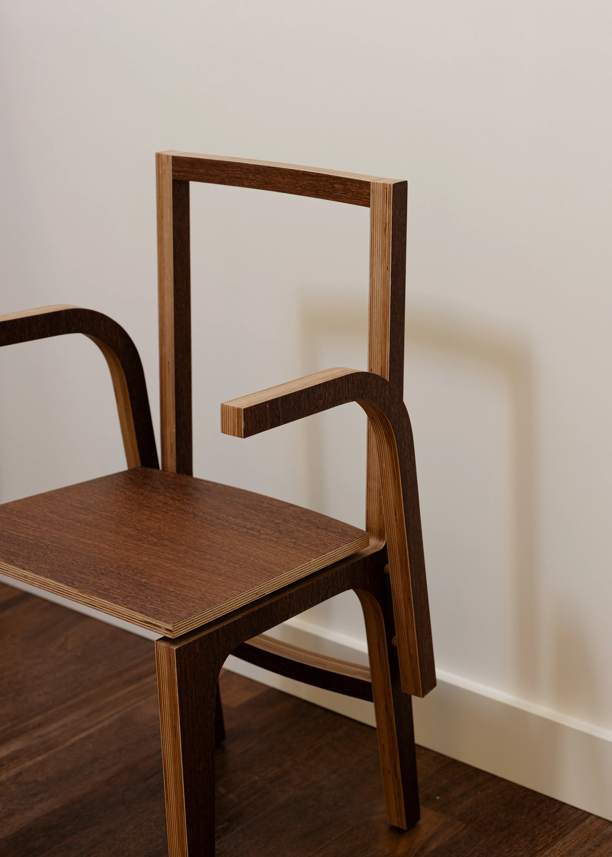 Da Boavista Church by Matos Gameiro arquitectos + atelier bugio — Bent plywood chair with laminated wood construction, featuring curved armrests and a geometric backrest frame.