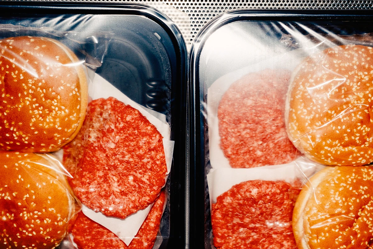 Lupine by Daniel Dorsa — Two black plastic containers filled with sliced cured meats and seeded bread rolls, arranged in parallel composition.