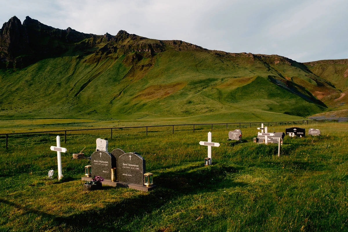 Lupine by Daniel Dorsa — A small rural cemetery sits beneath a dramatically striated mountain in southeastern Iceland.
