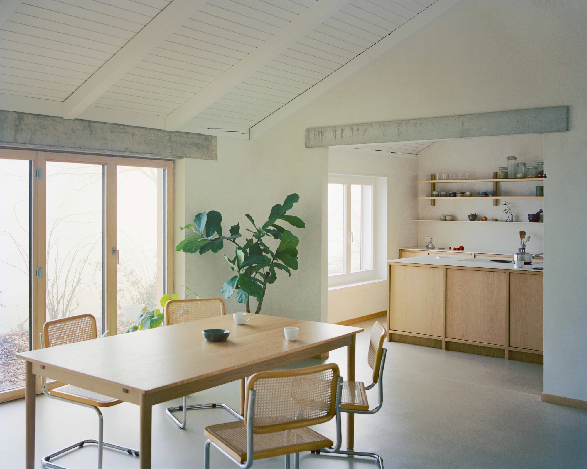 Family Villa by Noue Studio — The dining area occupies the reconfigured kitchen space, now repositioned as a living hub.