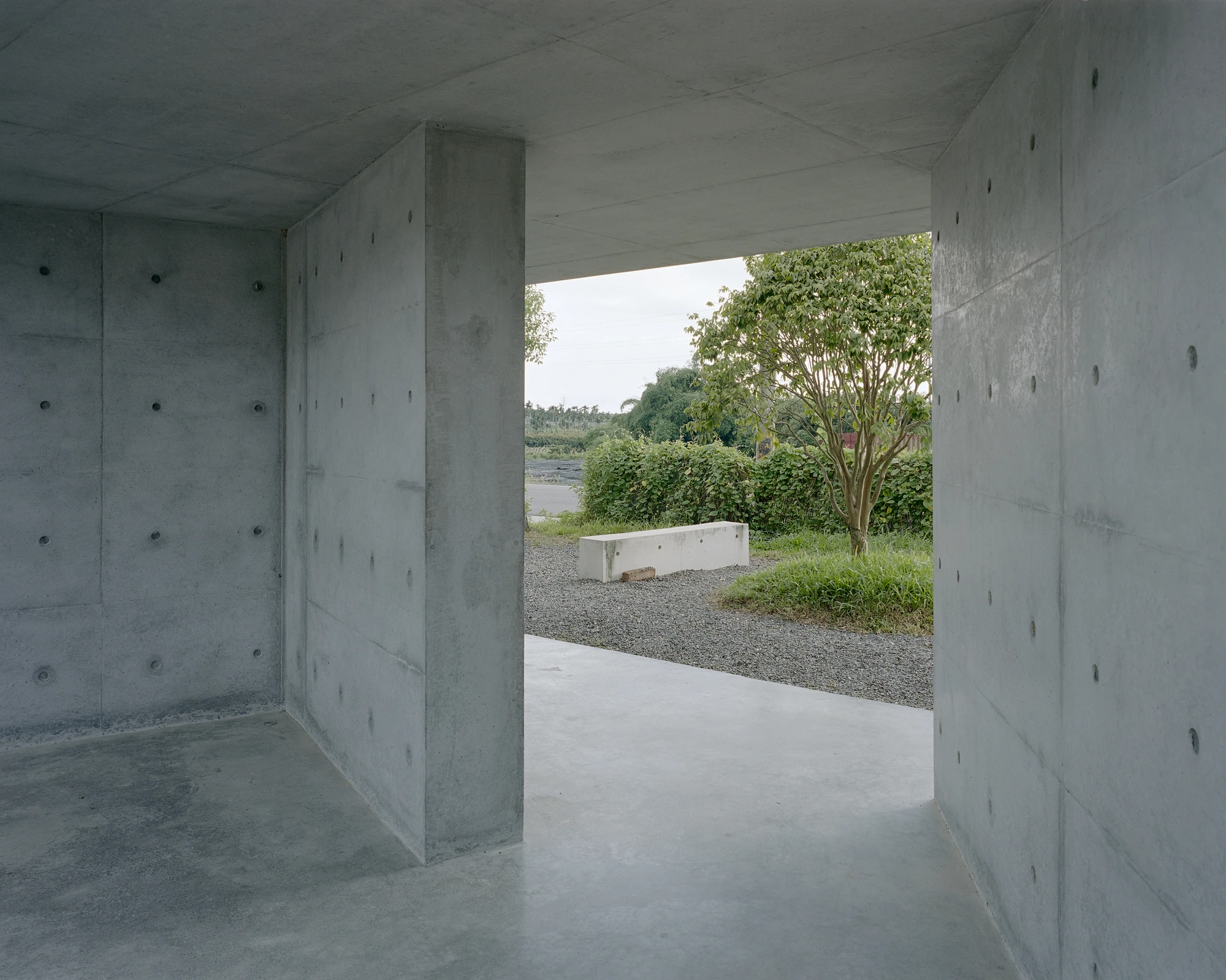 Entry Pavilion by metrics architecture studio — The pavilion's interior reveals its structural logic through a deep cantilevered roof slab that creates a dramatic shadow zone.