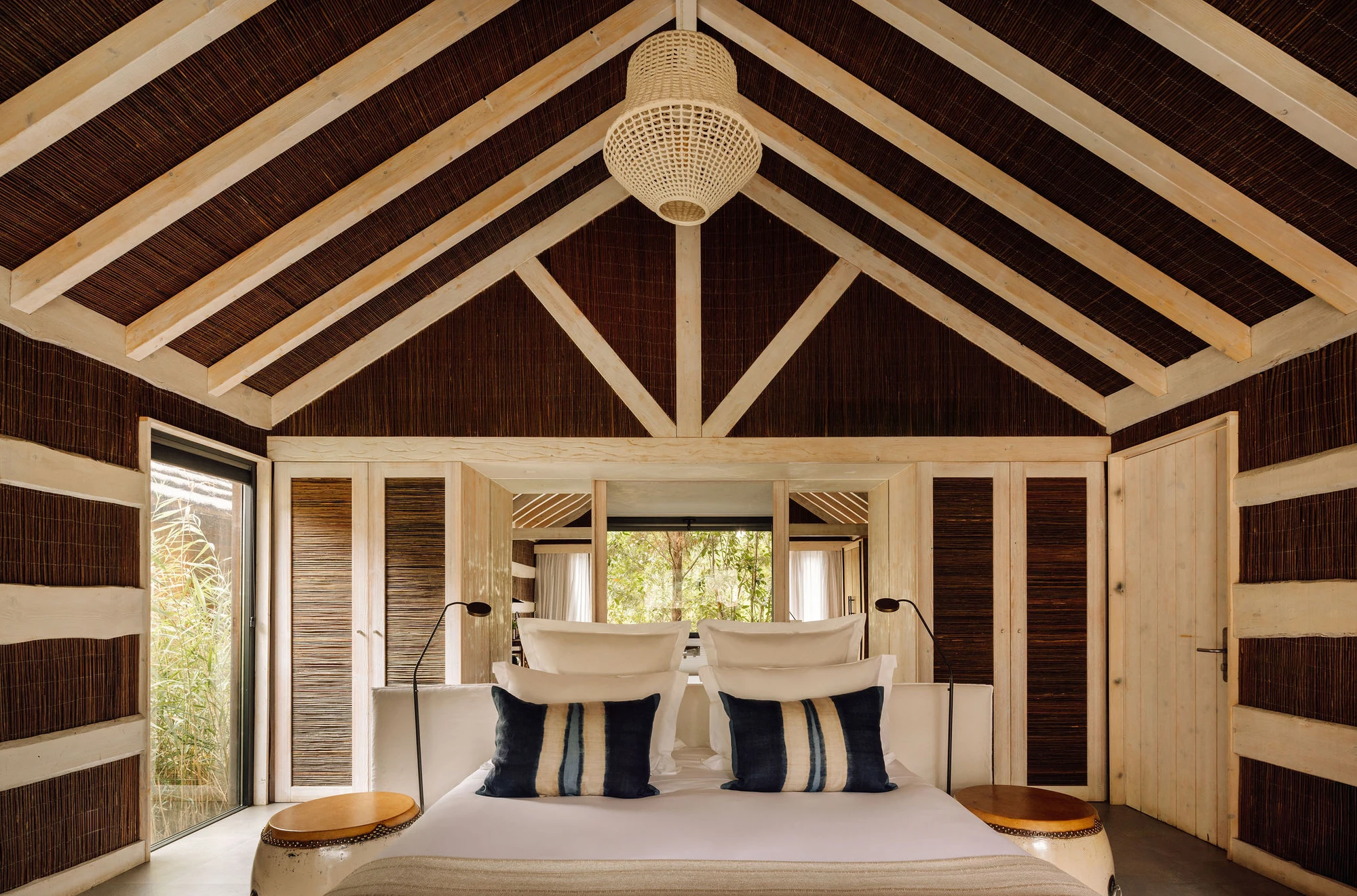 Sublime Comporta — A bedroom pavilion with exposed timber roof structure and pitched gable crowned by a woven pendant light.