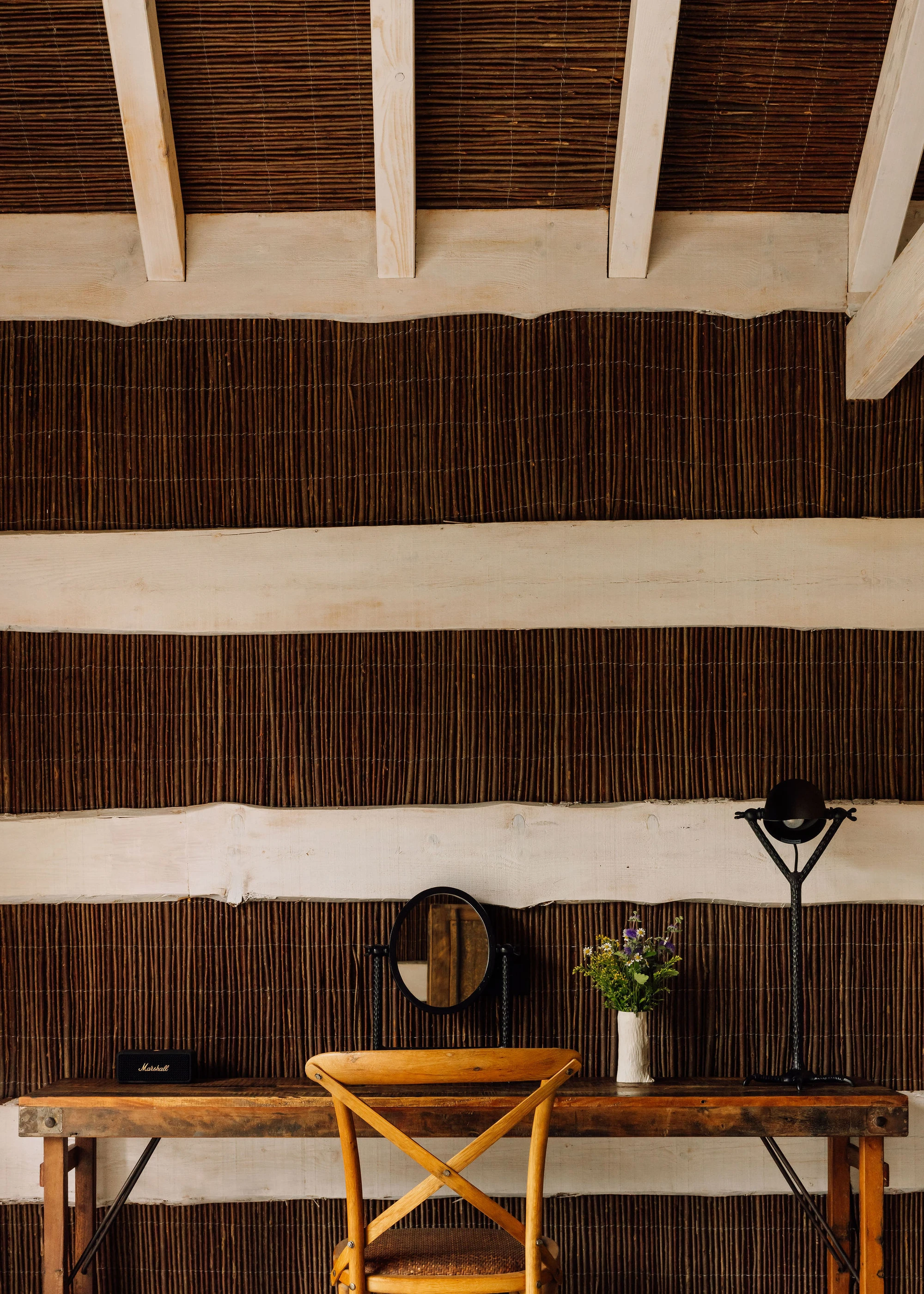 Sublime Comporta — Overhead view of a timber desk workspace within a bamboo-clad pavilion interior.
