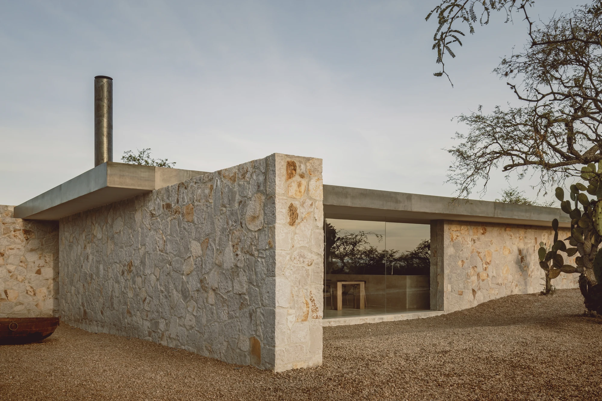Enso House II by HW Studio — HW Studio's Enso House II presents a coursed stone facade with pronounced horizontal stratification, its warm ochre and cream tones weathered by the San...