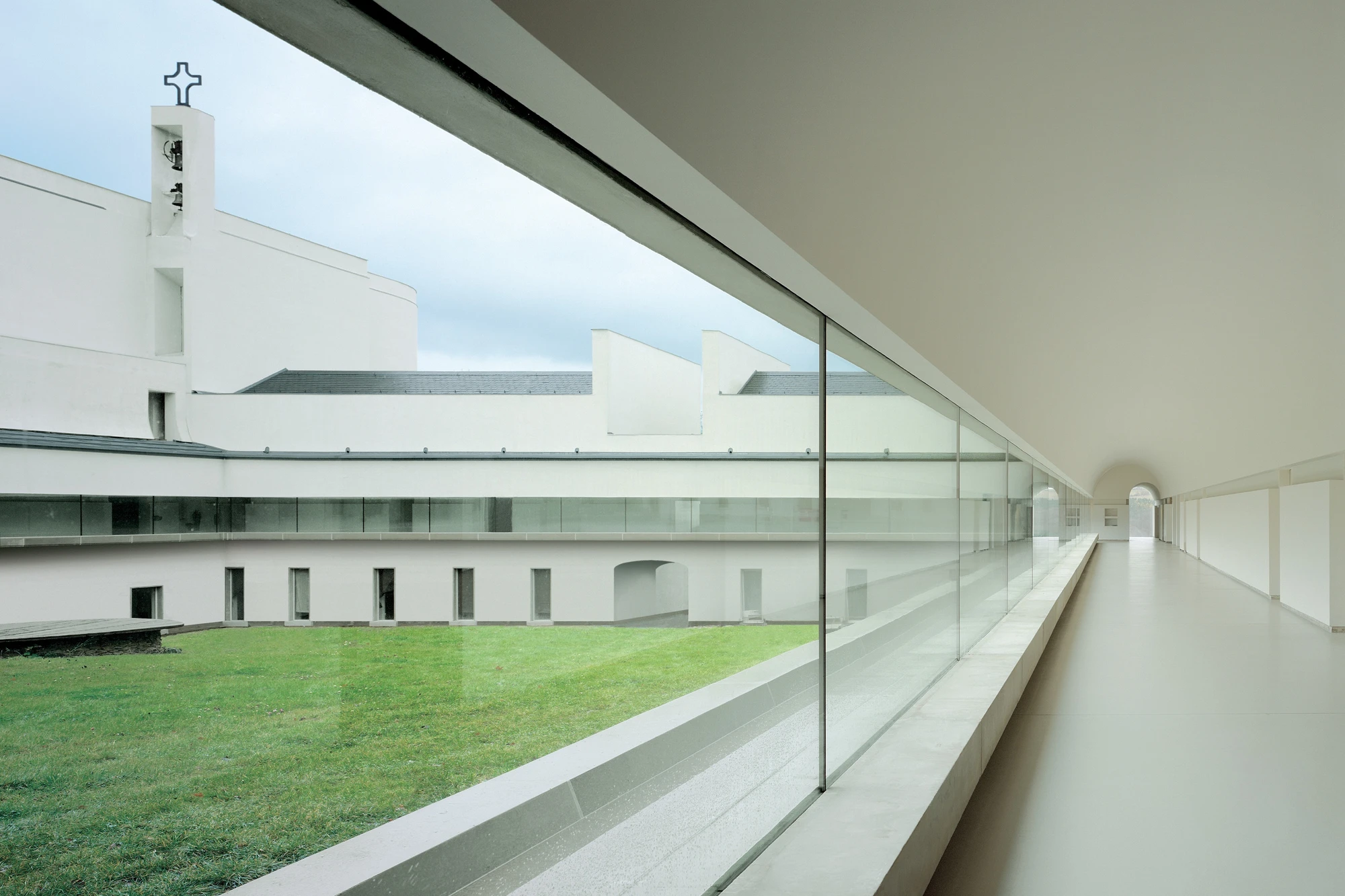 Abbey of Our Lady of Nový Dvůr by John Pawson — A glazed corridor frames the monastic courtyard with clinical precision.