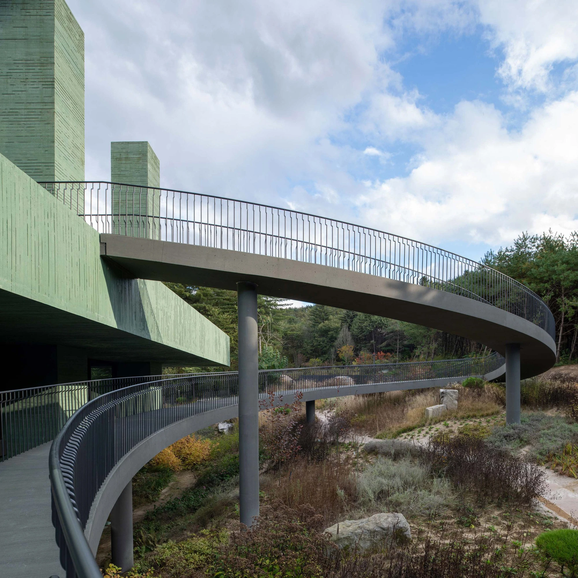 REST Garden Restaurant by Pezo von Ellrichshausen — Pezo von Ellrichshausen's REST Garden Restaurant unfolds across sloped terrain through a gridded colonnade of nine tapered concrete columns, each clad in...