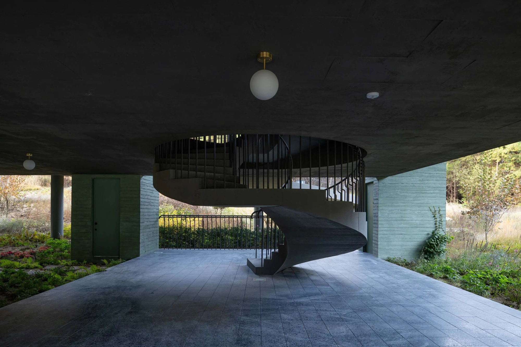 REST Garden Restaurant by Pezo von Ellrichshausen — Beneath a dark concrete ceiling plane, nine rectangular columns rise in strict grid formation, their soft green-tinted concrete surfaces marked by dark...