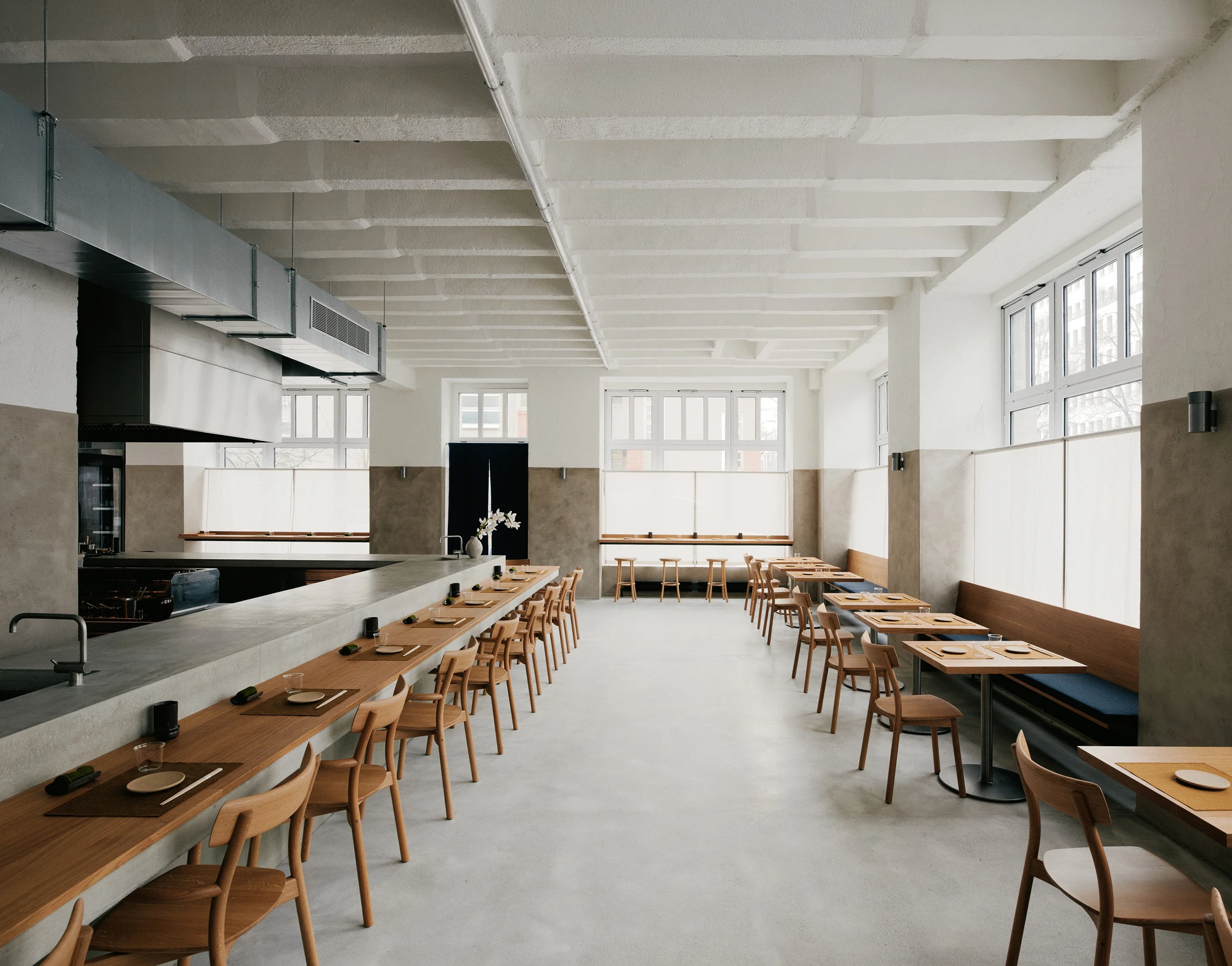 Stoke Restaurant by Studio Mark Randel — Stoke's dining hall extends longitudinally beneath exposed ribbed concrete ceiling beams, their formwork marks preserved.