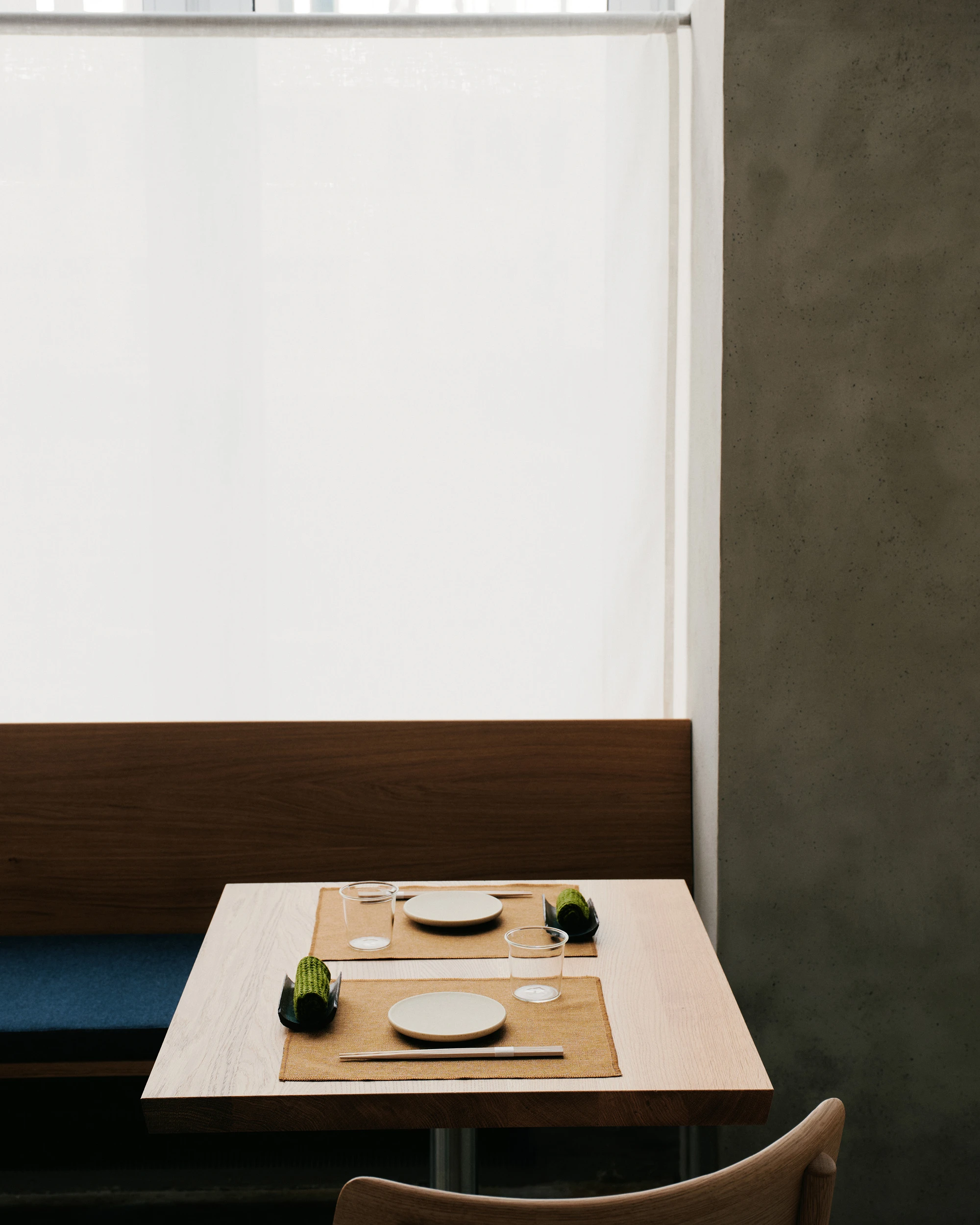 Stoke Restaurant by Studio Mark Randel — A table setting for two at Stoke demonstrates the restaurant's restrained material vocabulary.