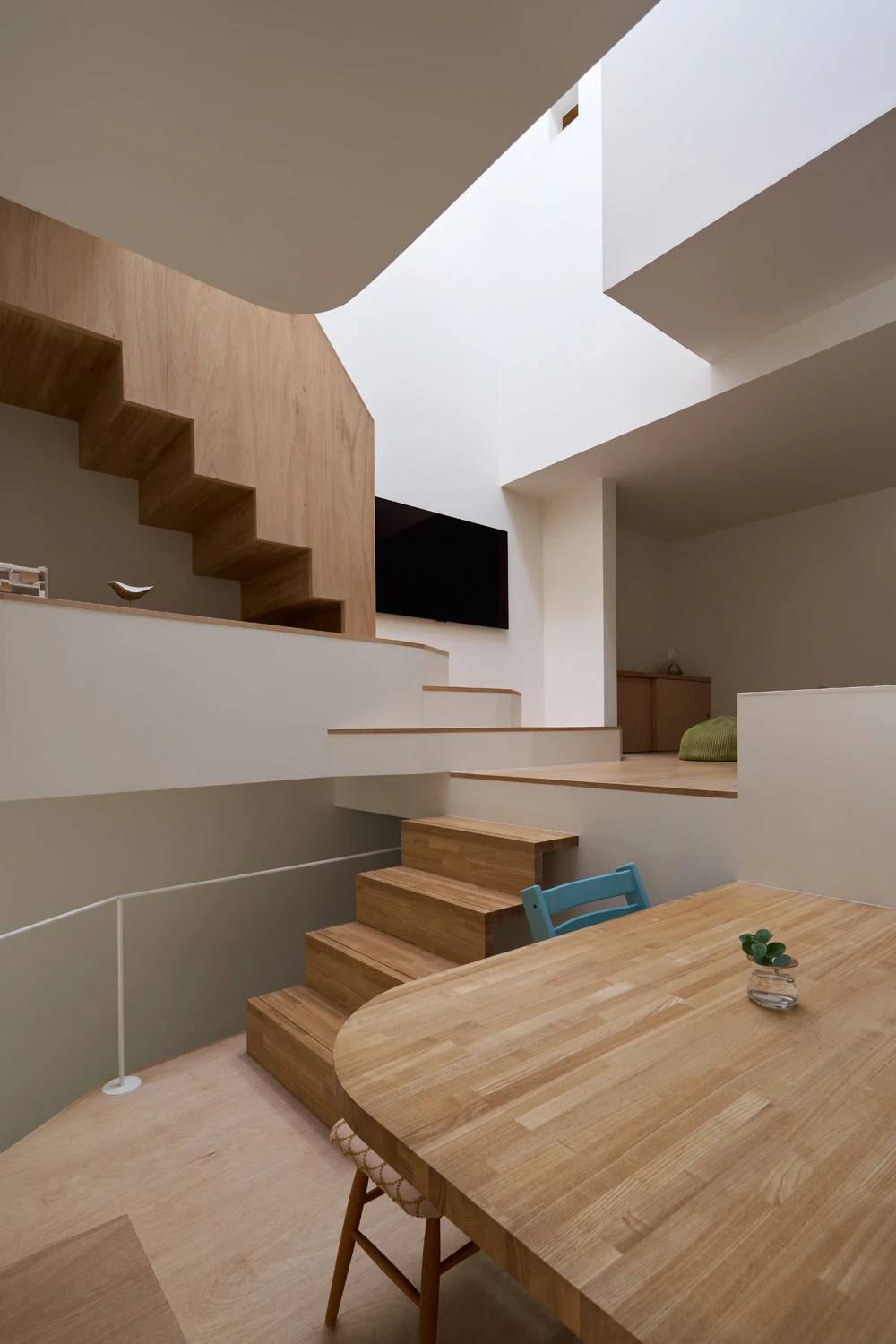 House in Hirano by Fujiwaramuro Architects — Interior view of the Hirano house reveals a multi-level wooden staircase that serves as both circulation and spatial organizer.
