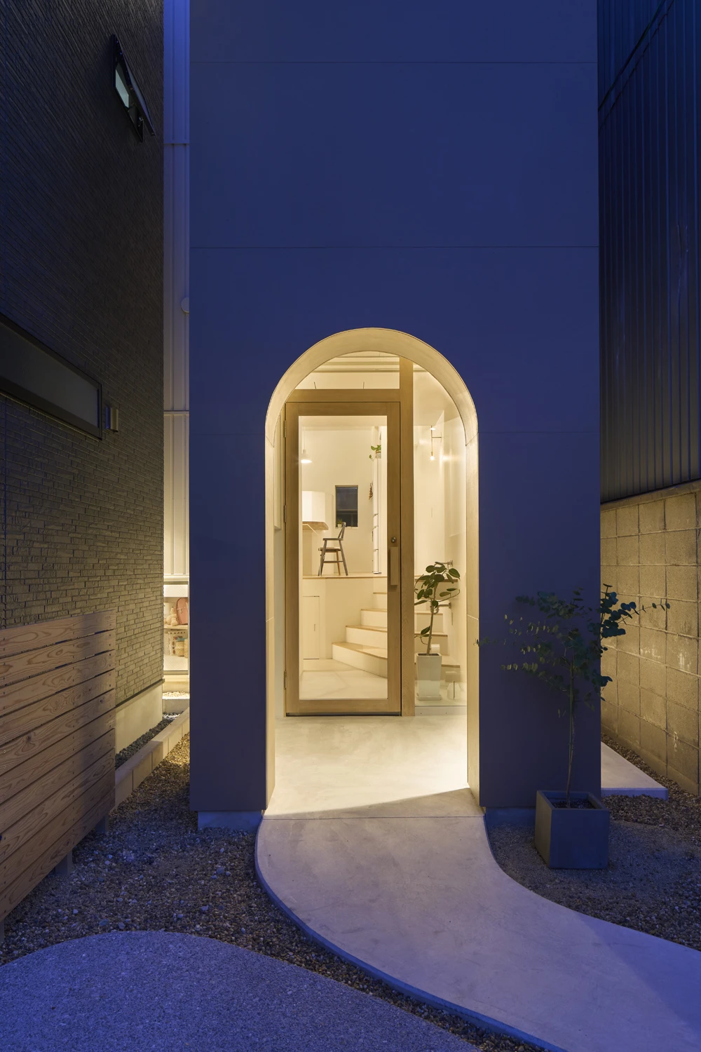 House in Hirano by Fujiwaramuro Architects — Night photograph of the street-level entry to House in Hirano, revealing the project's solution to the constrained flagpole lot.