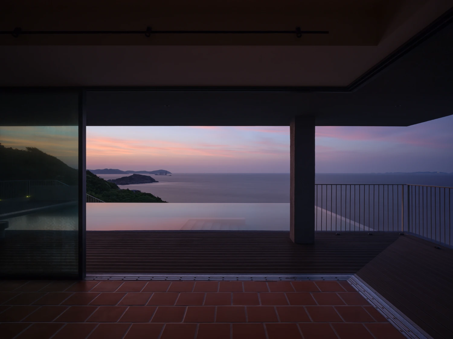 Lost Villa Shengsi Huanglong Island Lighthouse Hotel by SZ-Architects — A covered terrace frames the sunset across Shengsi's archipelago through floor-to-ceiling glazing.