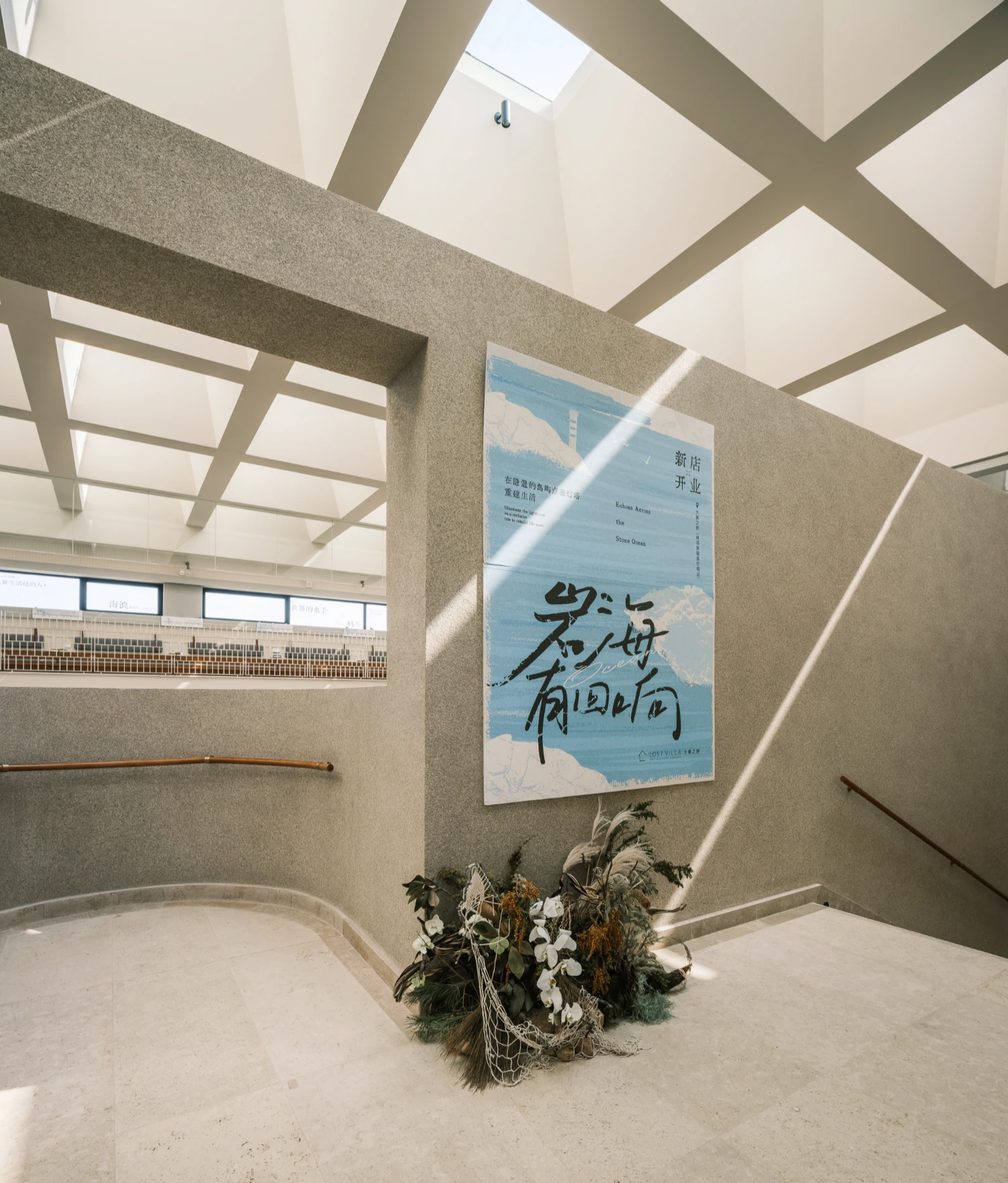 Lost Villa Shengsi Huanglong Island Lighthouse Hotel by SZ-Architects — A double-height atrium floor preserves raw geological material—an unfinished granite boulder and loose sand—within a refined architectural envelope.