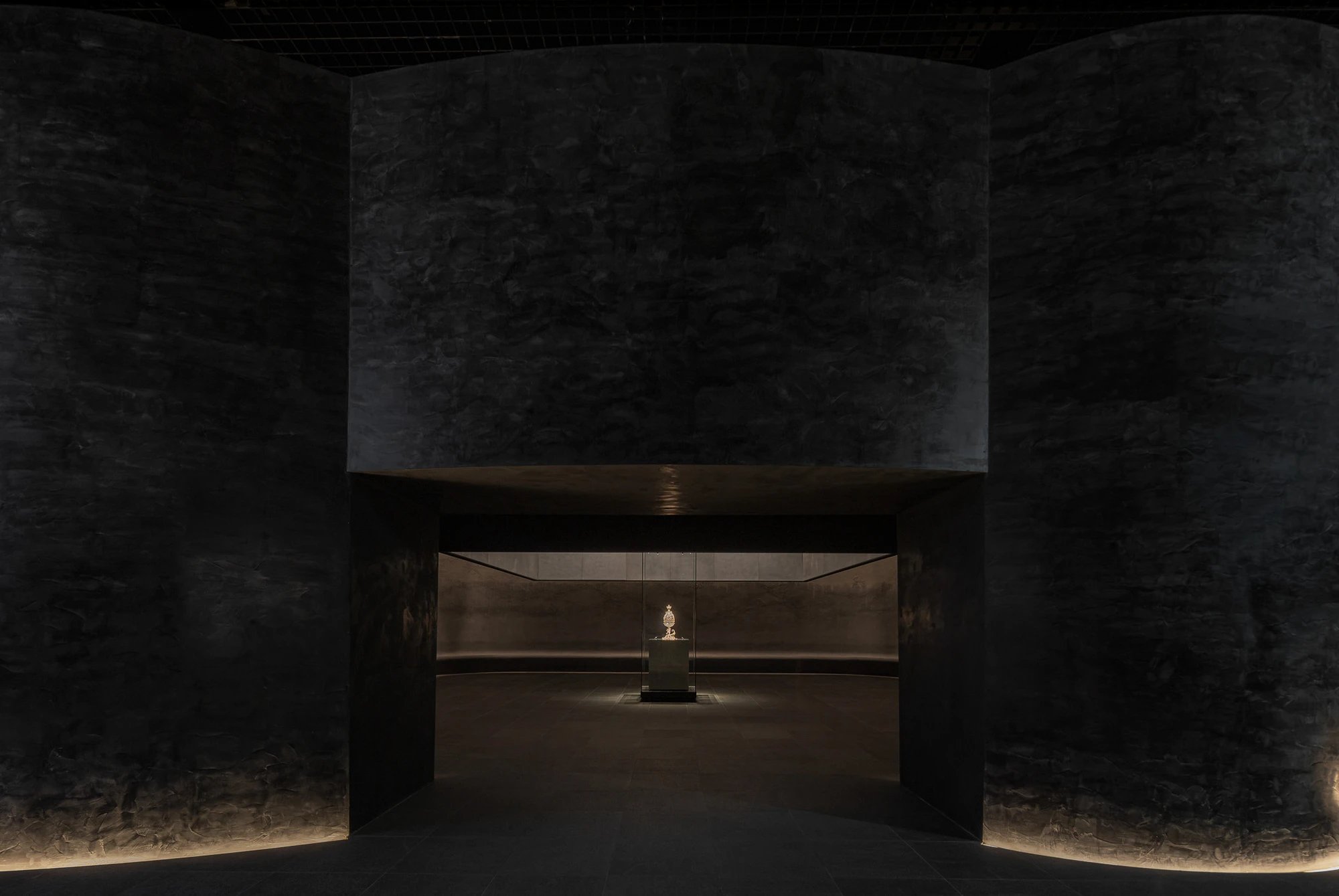 Baekje Gilt Bronze Incense Burner Hall (Buyeo National Museum) by WGNB — A threshold view into the Baekje Gilt Bronze Incense Burner Hall reveals the sculptural object positioned centrally within a darkened interior.