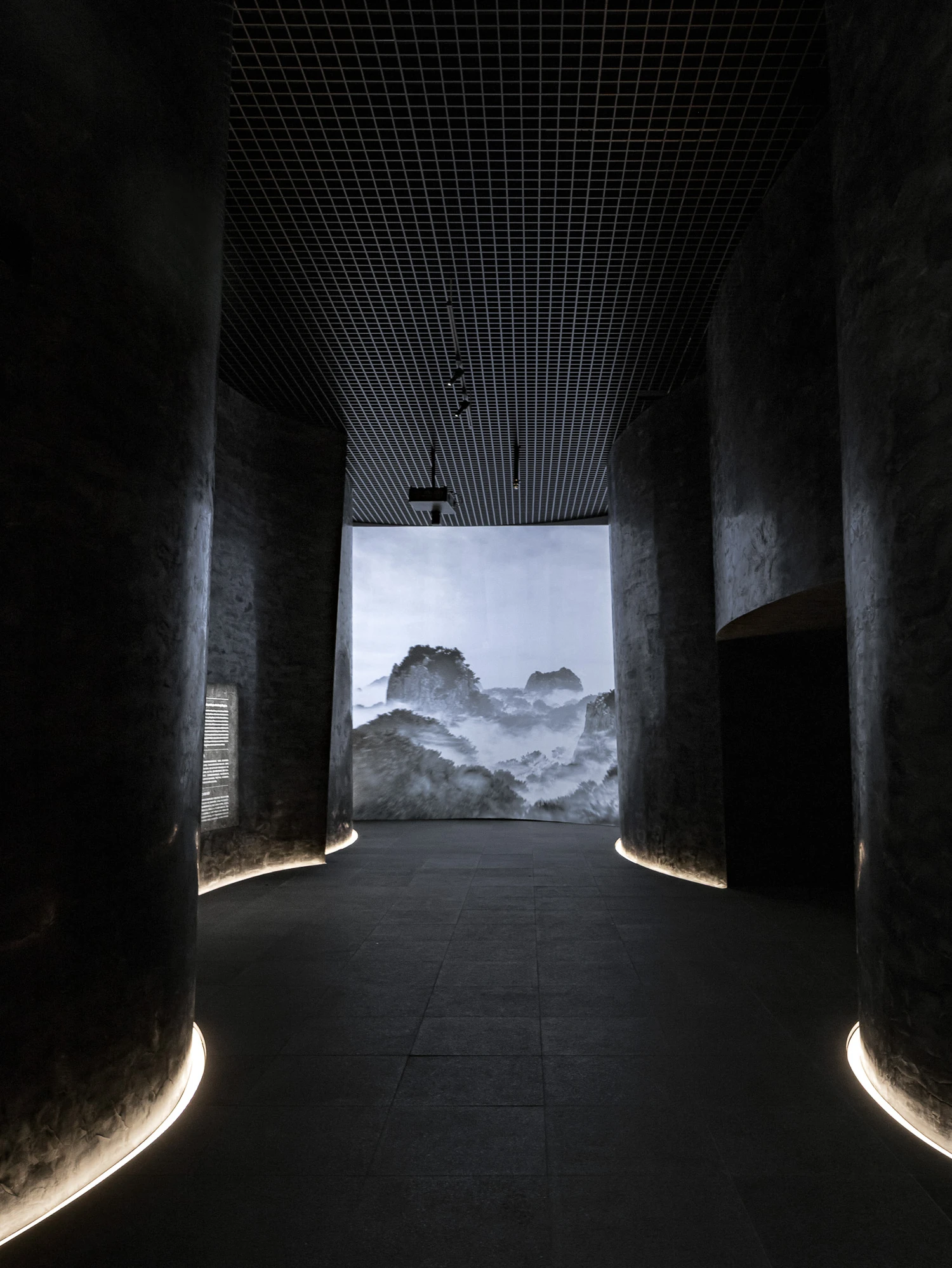 Baekje Gilt Bronze Incense Burner Hall (Buyeo National Museum) by WGNB — A concrete corridor frames a mountainous landscape photograph positioned at the far end of a symmetrical passage.
