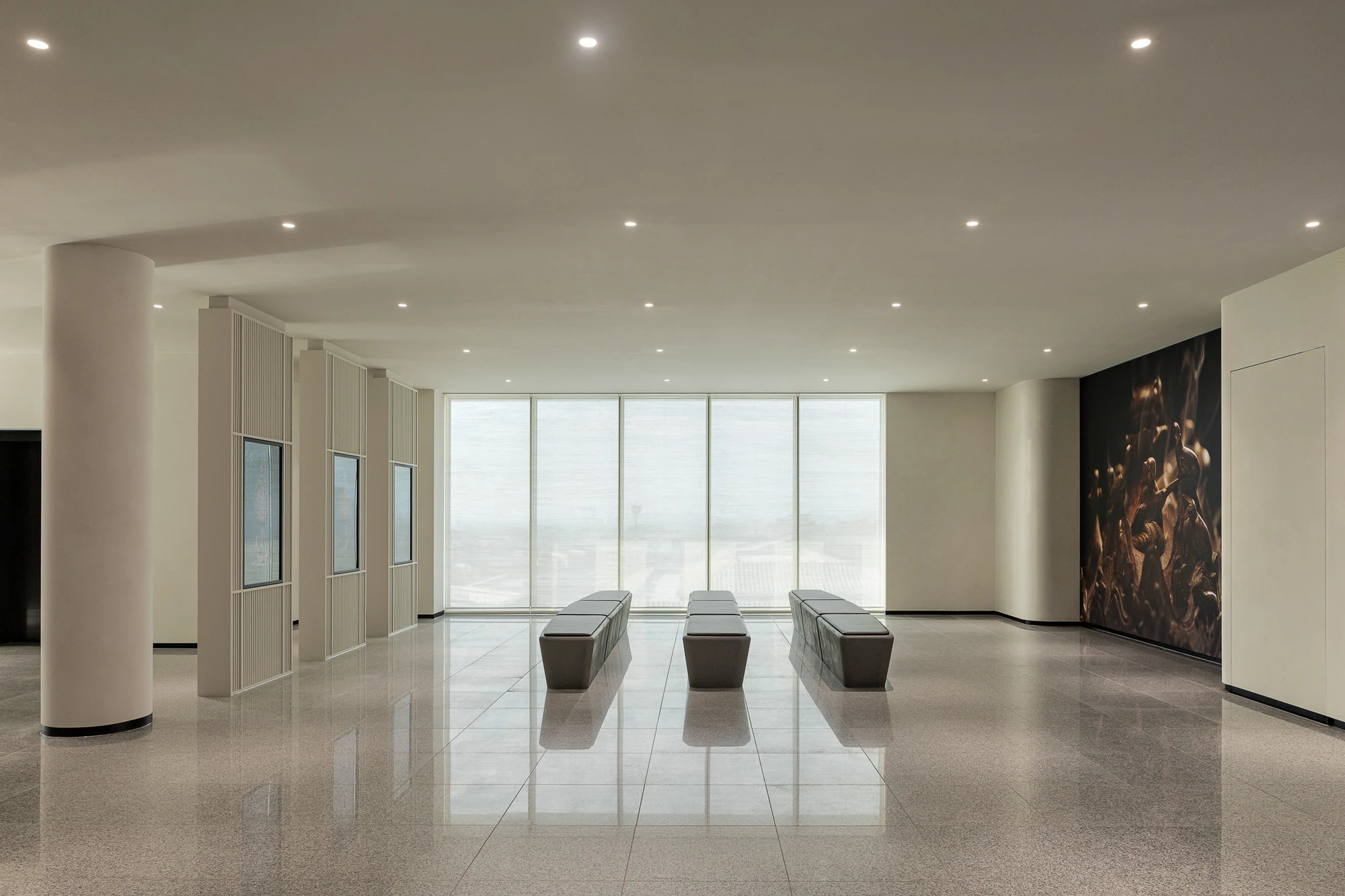 Baekje Gilt Bronze Incense Burner Hall (Buyeo National Museum) by WGNB — A high-ceilinear gallery interior defined by recessed ceiling lights and floor-to-ceiling glazing that frames an expansive skyline view.