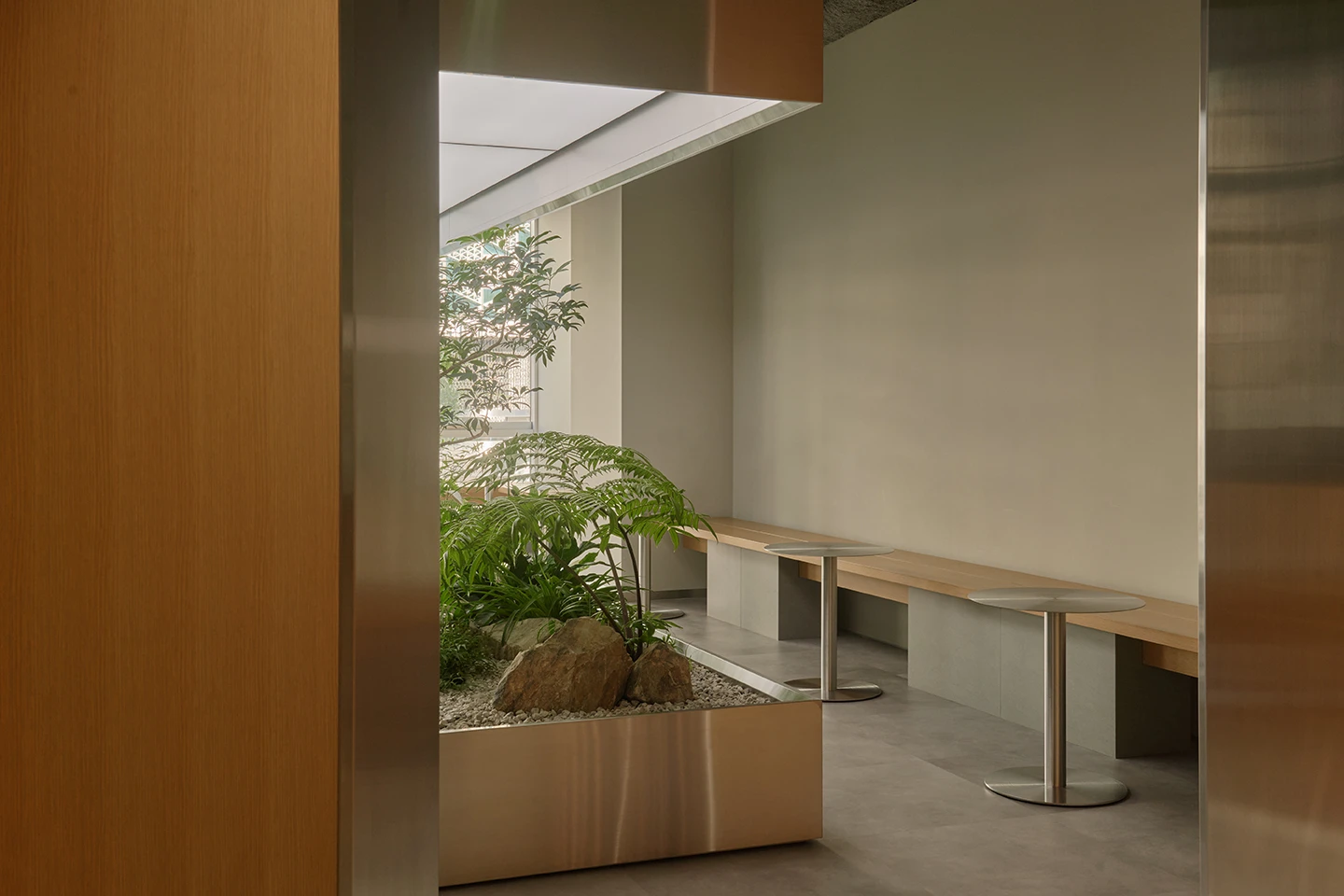 Alchemist Aoyama by Wynk Collaborative — A passage framed by timber-clad walls opens onto an internal garden court.