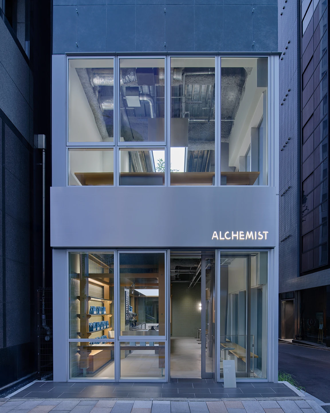 Alchemist Aoyama by Wynk Collaborative — The street-facing facade of Alchemist Aoyama presents a dual-plane composition: ground-level glazing frames the interior coffee counter with wooden column...