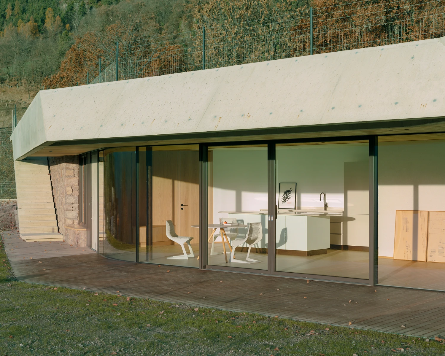 Casa Conte by Messner Architects — A timber-clad residential pavilion extends horizontally across a sloped Alpine site, anchored by a monolithic concrete cantilever that projects dramatically...