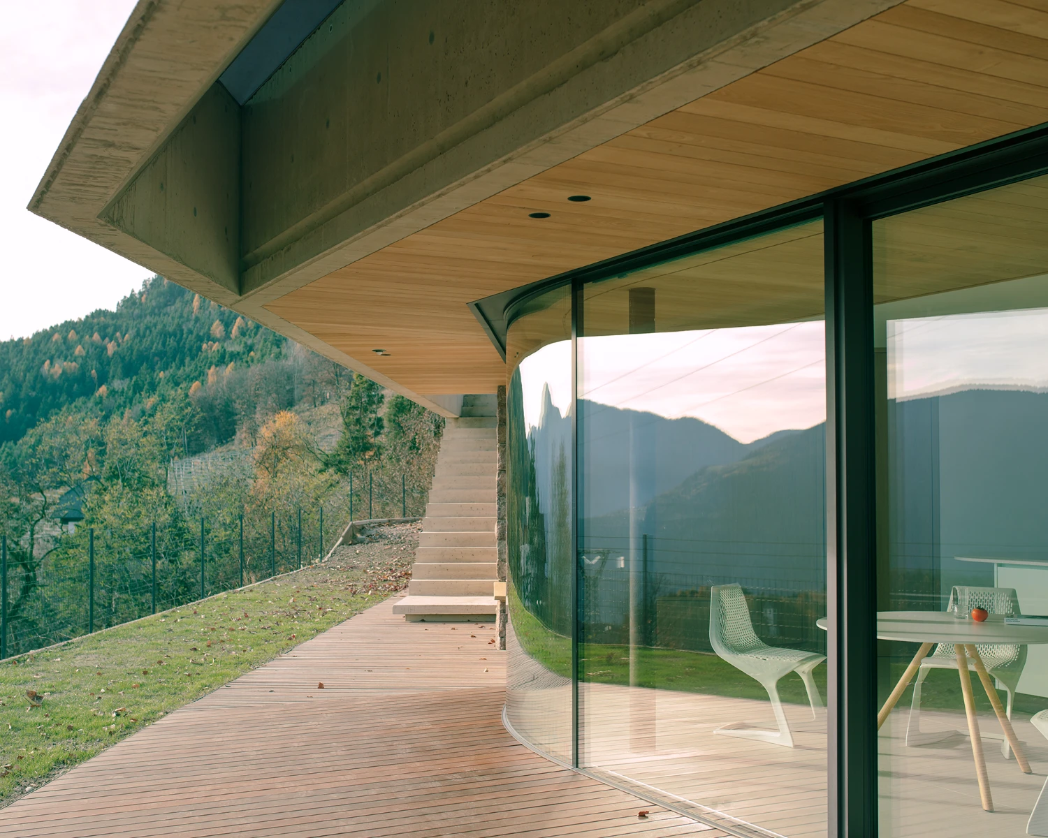 Casa Conte by Messner Architects — A cantilevered concrete slab extends horizontally across the slope, its flat soffit punctuated by recessed downlights.