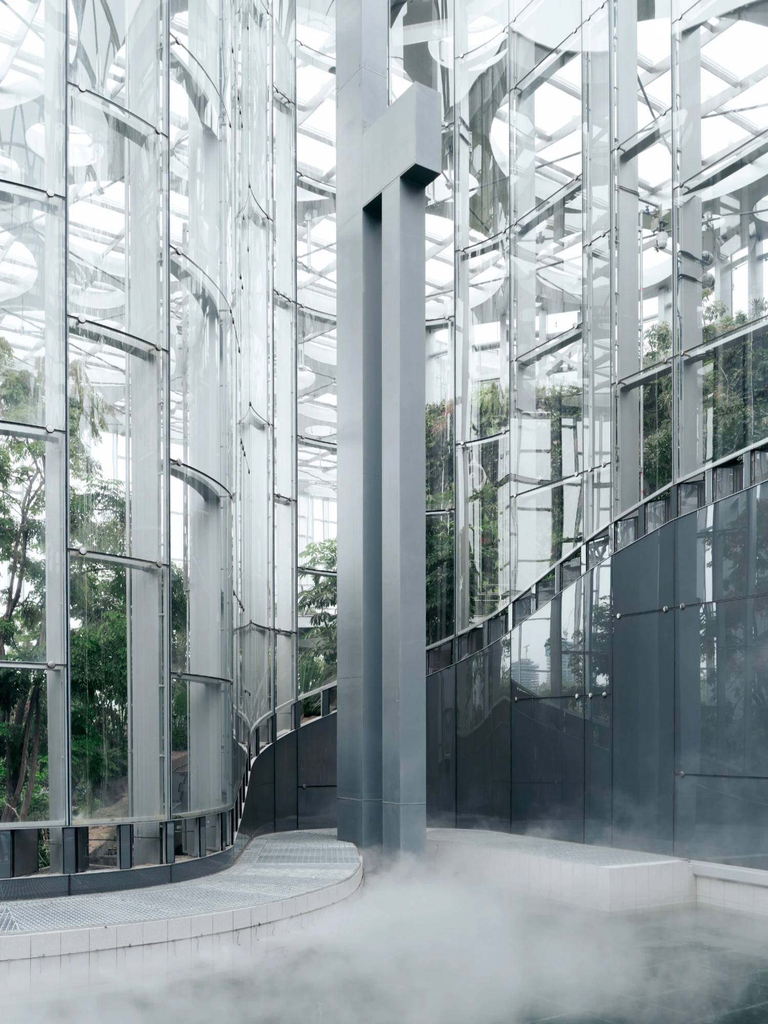Expo Cultural Park Greenhouse Garden by Delugan Meissl captured by Marcus Yau — A vertical steel column rises through the greenhouse's interior, anchoring the composition within a framework of glass and metal.