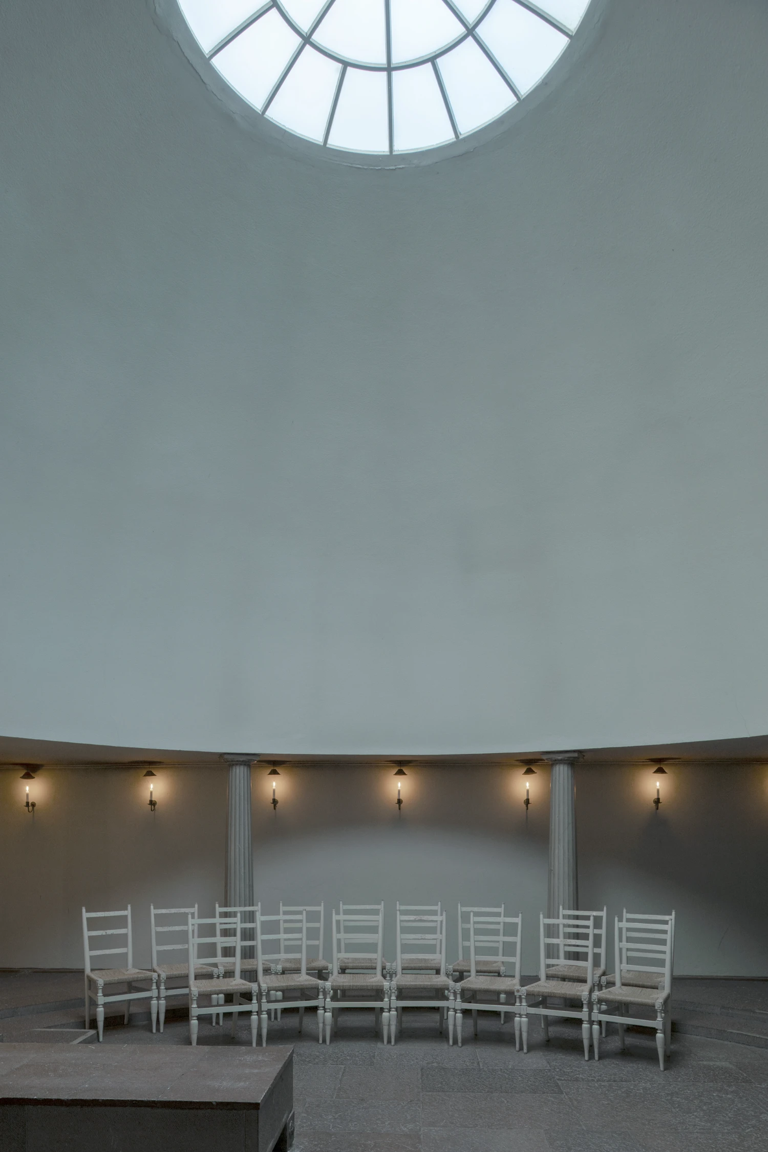 Woodland Cemetery Stockholm captured by Andy Liffner — A circular interior chapel defined by a radial skylight with geometric muntins flooding the space with diffuse natural light.