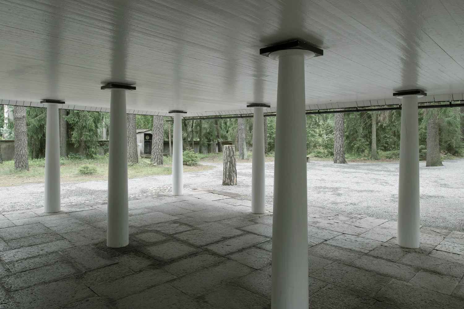 Woodland Cemetery Stockholm captured by Andy Liffner — A covered pavilion structure in the Woodland Cemetery defines a geometric threshold between forest and clearing.