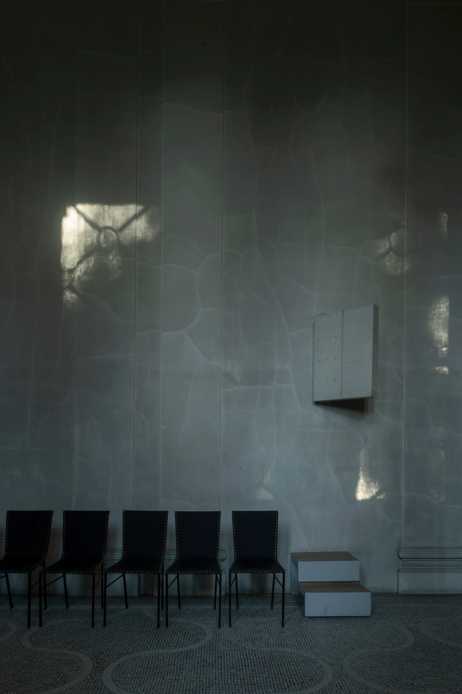 Woodland Cemetery Stockholm captured by Andy Liffner — Interior passage within Woodland Cemetery's chapel structure, characterized by vertical wood-paneled walls in pale grey-white render or plaster.