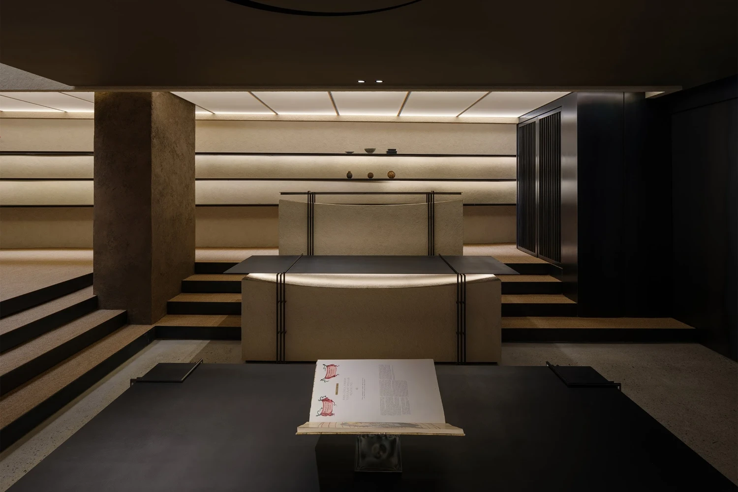 The Graphic bookstore by OONN Metaworks + U.LAB — Interior view of The Graphic bookstore reveals a ceremonial display counter positioned at the center of a symmetrical, tiered space.