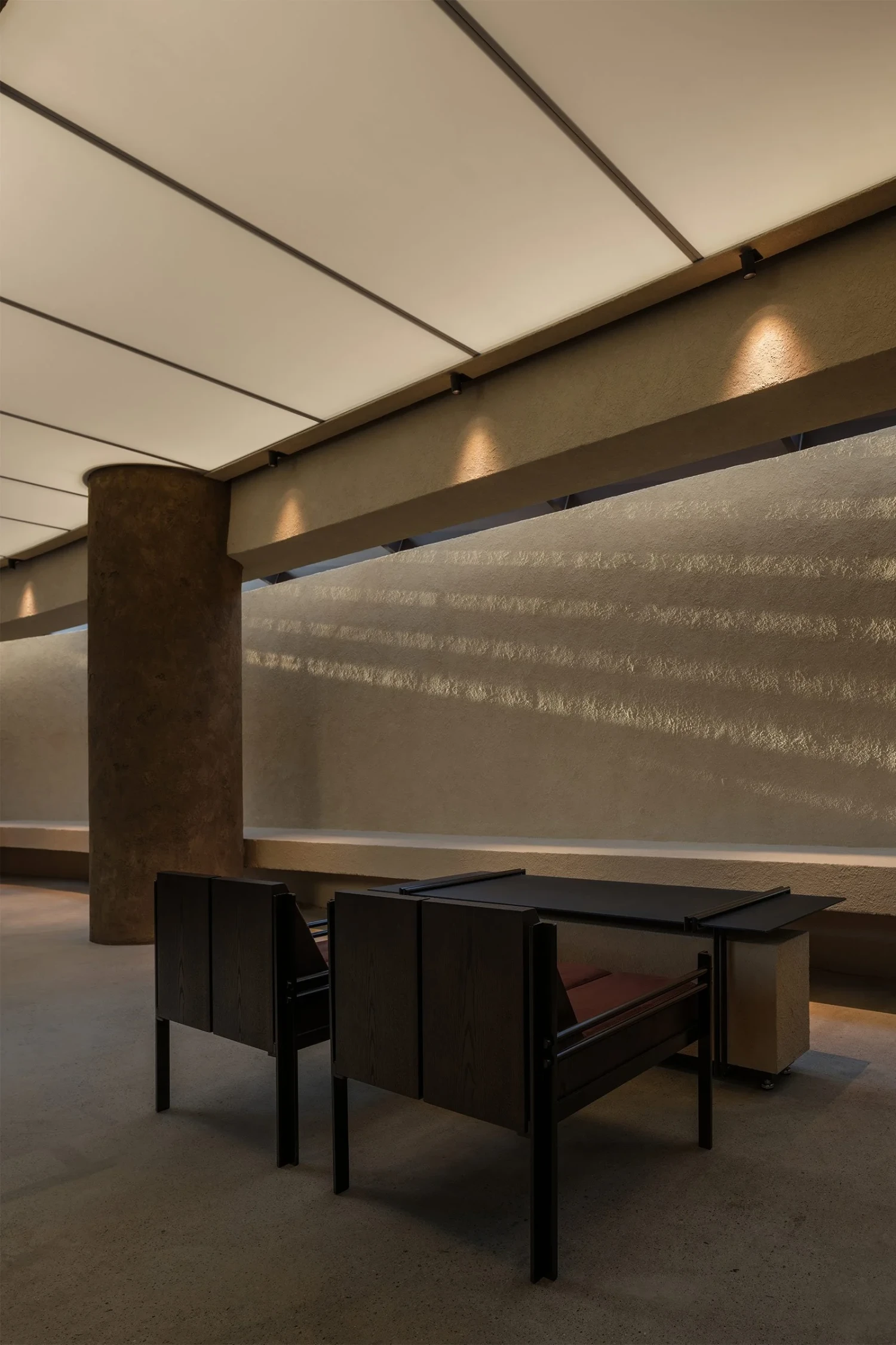 The Graphic bookstore by OONN Metaworks + U.LAB — Interior view of The Graphic bookstore reveals a minimalist seating arrangement beneath a coffered ceiling with recessed lighting.