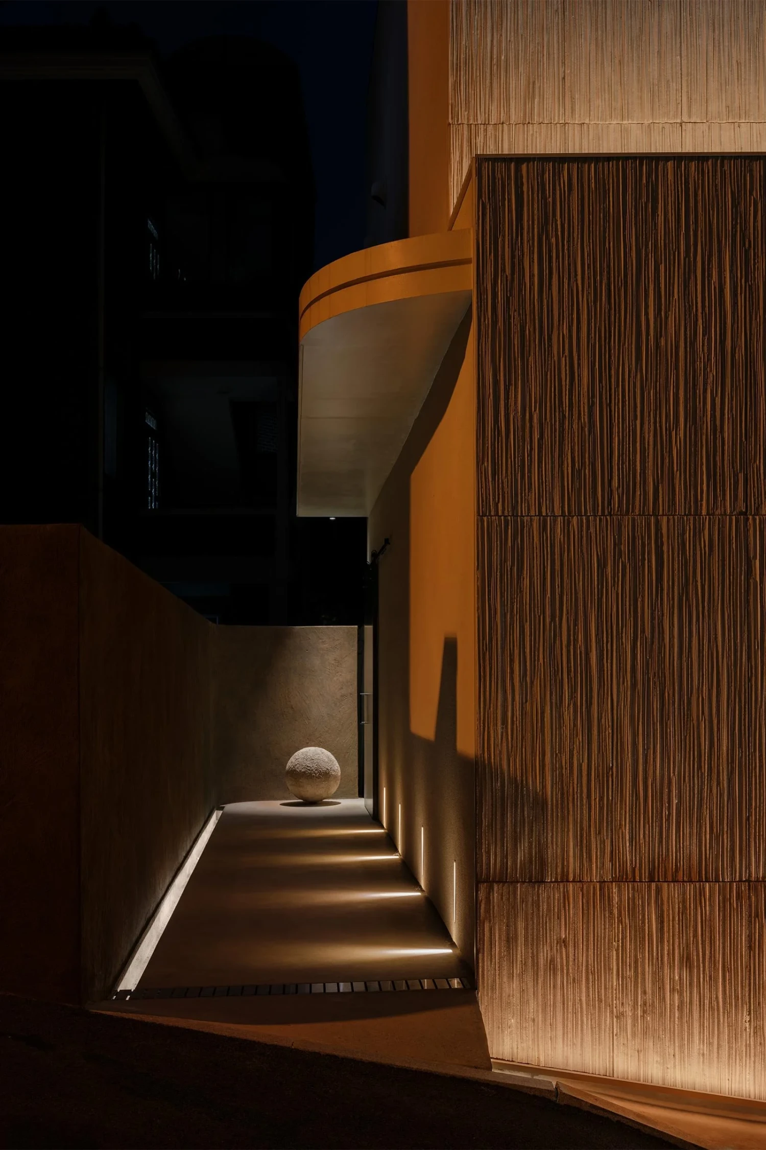 The Graphic bookstore by OONN Metaworks + U.LAB — A narrow passage reveals the bookstore's restrained street presence.