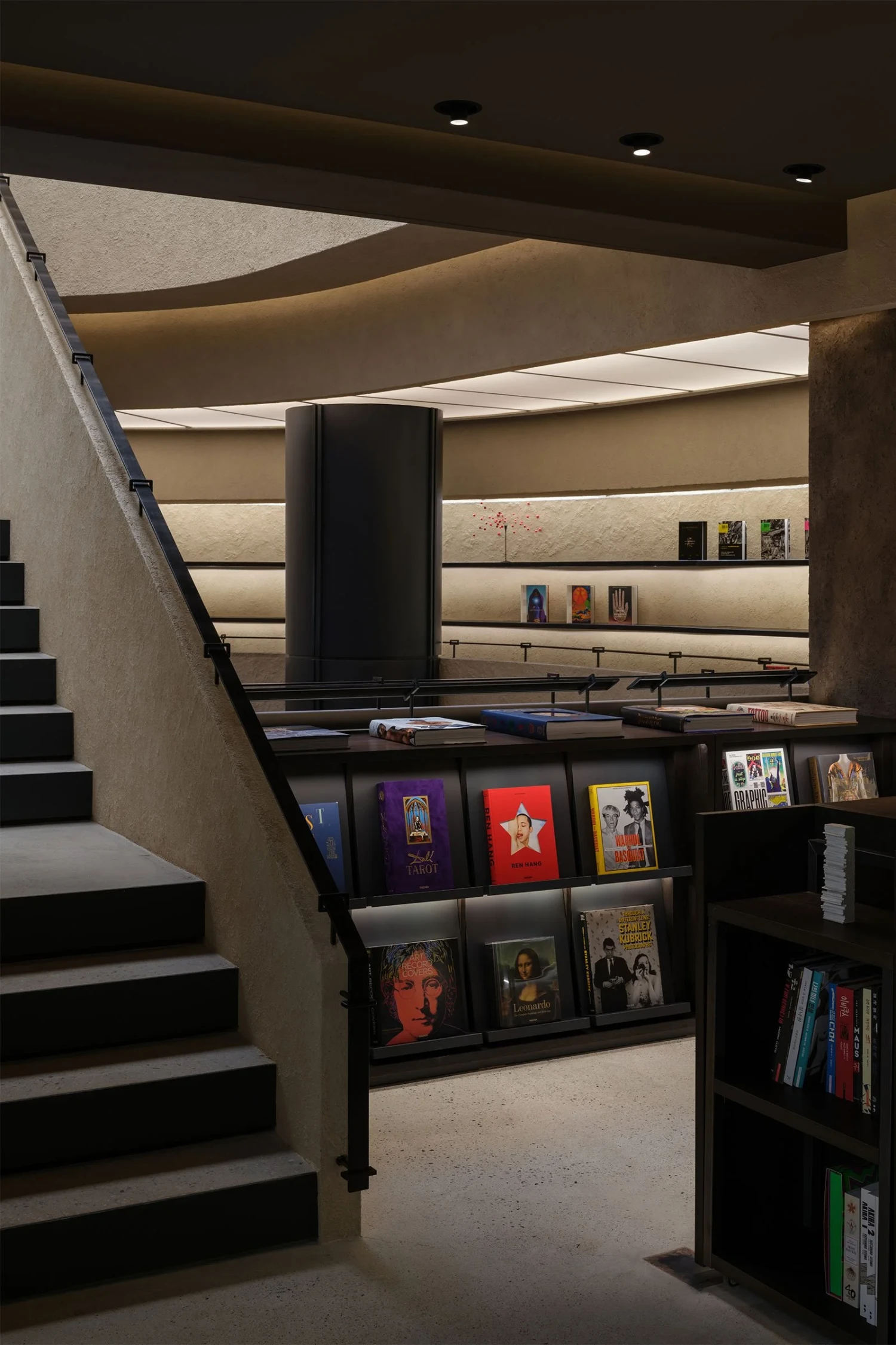 The Graphic bookstore by OONN Metaworks + U.LAB — A multi-level interior volume defined by horizontal timber shelving and black metal framework.