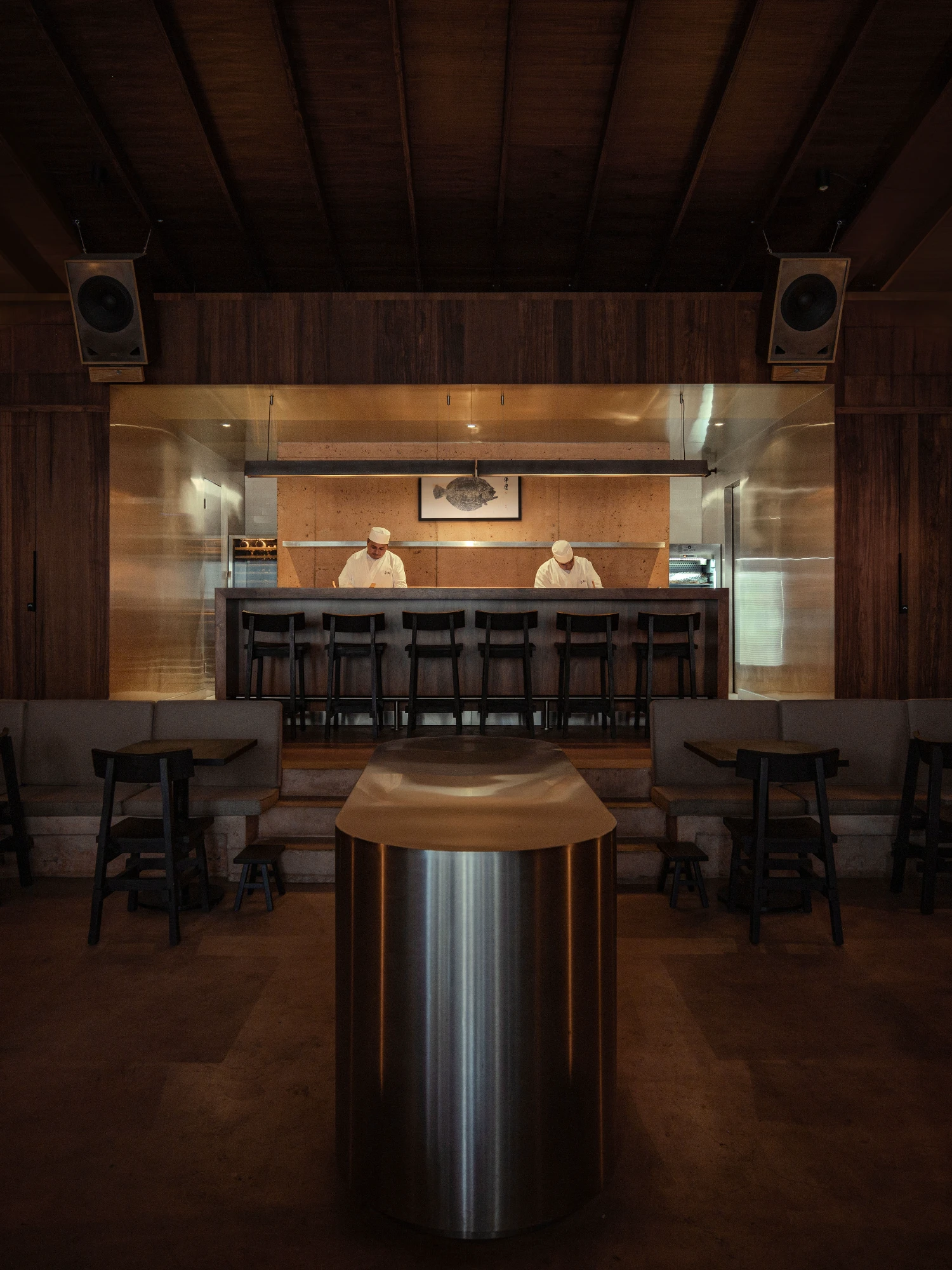 ZUKE Restaurant by Sofía Betancur + Taller Nacional — The sushi counter anchors a symmetrically organized dining space defined by deep timber surfaces and controlled lighting.
