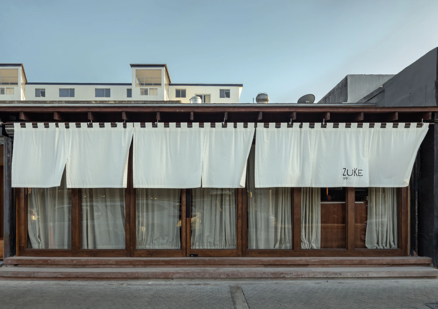 ZUKE Restaurant by Sofía Betancur + Taller Nacional — The storefront presents a studied composition of industrial restraint.